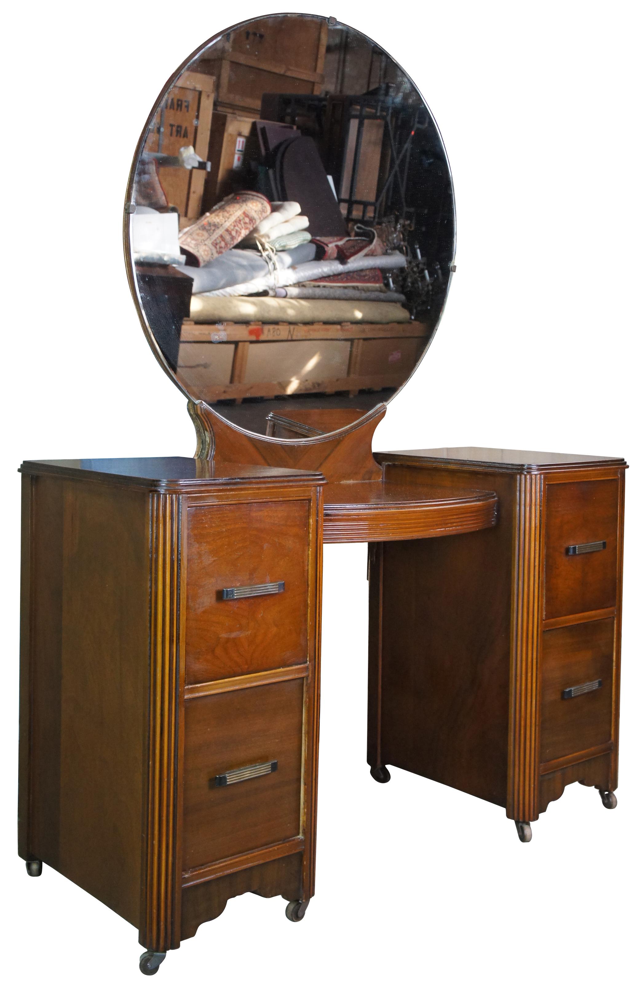Antique Johnson Carper Furniture Co Art Deco vanity or dressing table. Made of walnut featuring Art Deco styling with fluting and large circular mirror. Produced by Johnson Carper out of Roanoke,Va. 

Measures: 18