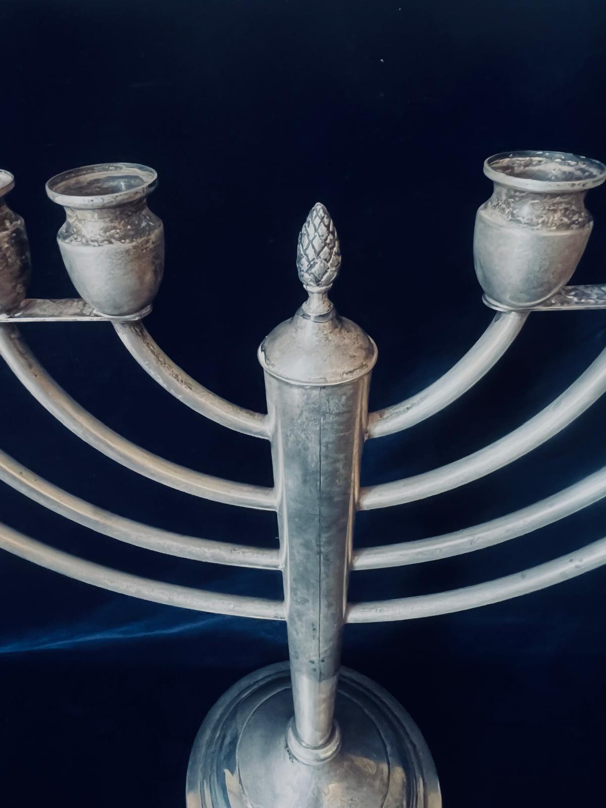 An exceptional classical sterling silver straight lined art deco Menorah with eight candle holders, on the top in the center there is a pine cone which represents and symbolizes human enlightenment, resurrection, eternal life and regeneration. We