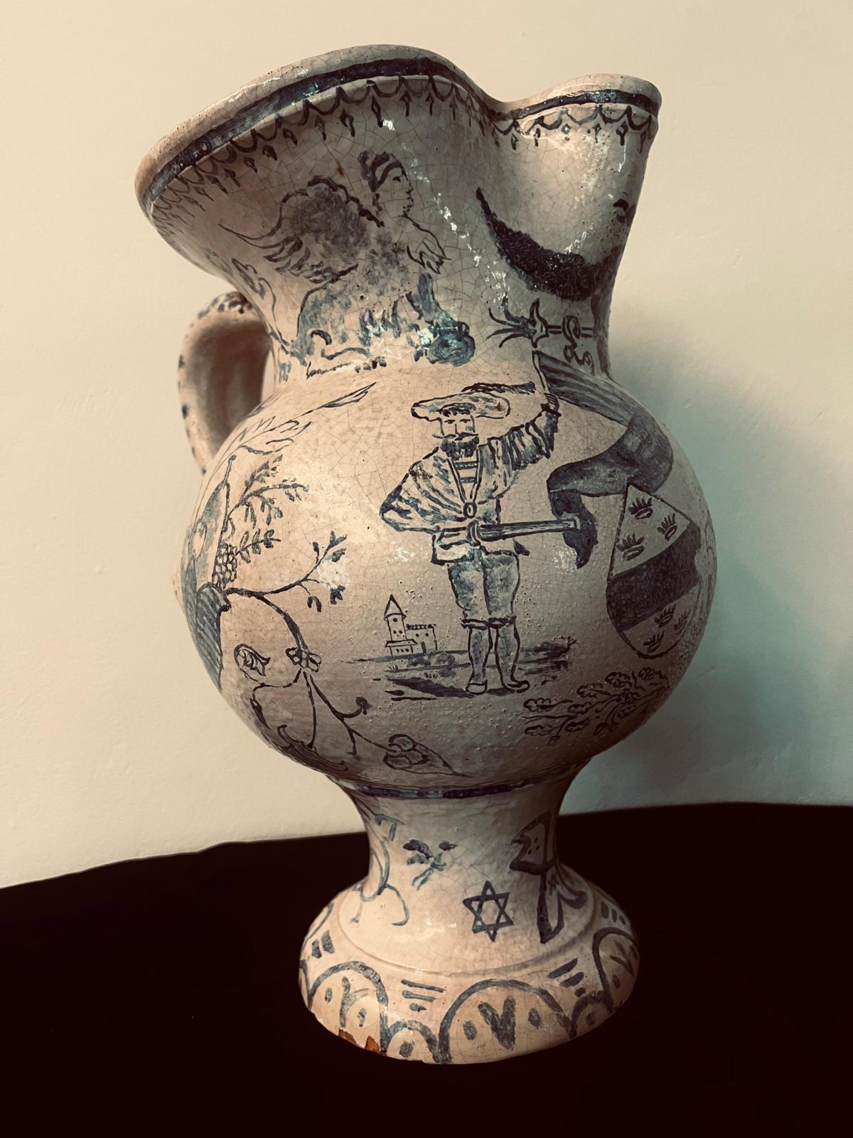 Cette remarquable cruche en céramique ancienne, datant probablement de la fin du XVIIIe siècle, est un témoignage de l'artisanat symbolique et de l'imbrication des cultures. Son corps en glaçure blanche, orné de motifs complexes peints à la main en