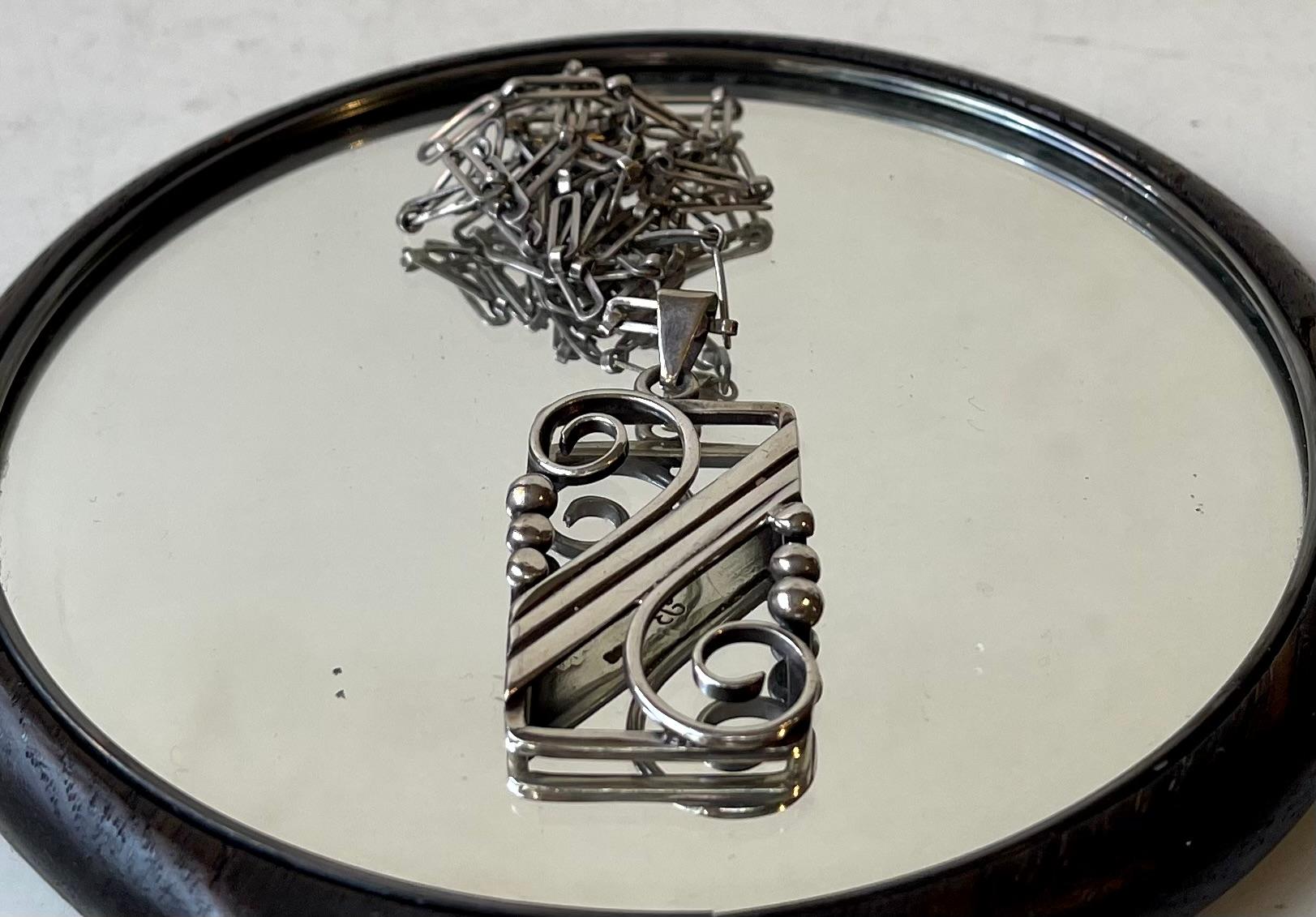 Ein handgefertigter Silberanhänger aus den 1920er Jahren mit originaler 60 cm langer handgefertigter Kette in einem ungewöhnlichen Muster. Hergestellt von dem dänischen Silberschmied F. Bang um 1920 in einem Stil, der an Georg Jensen erinnert. Die