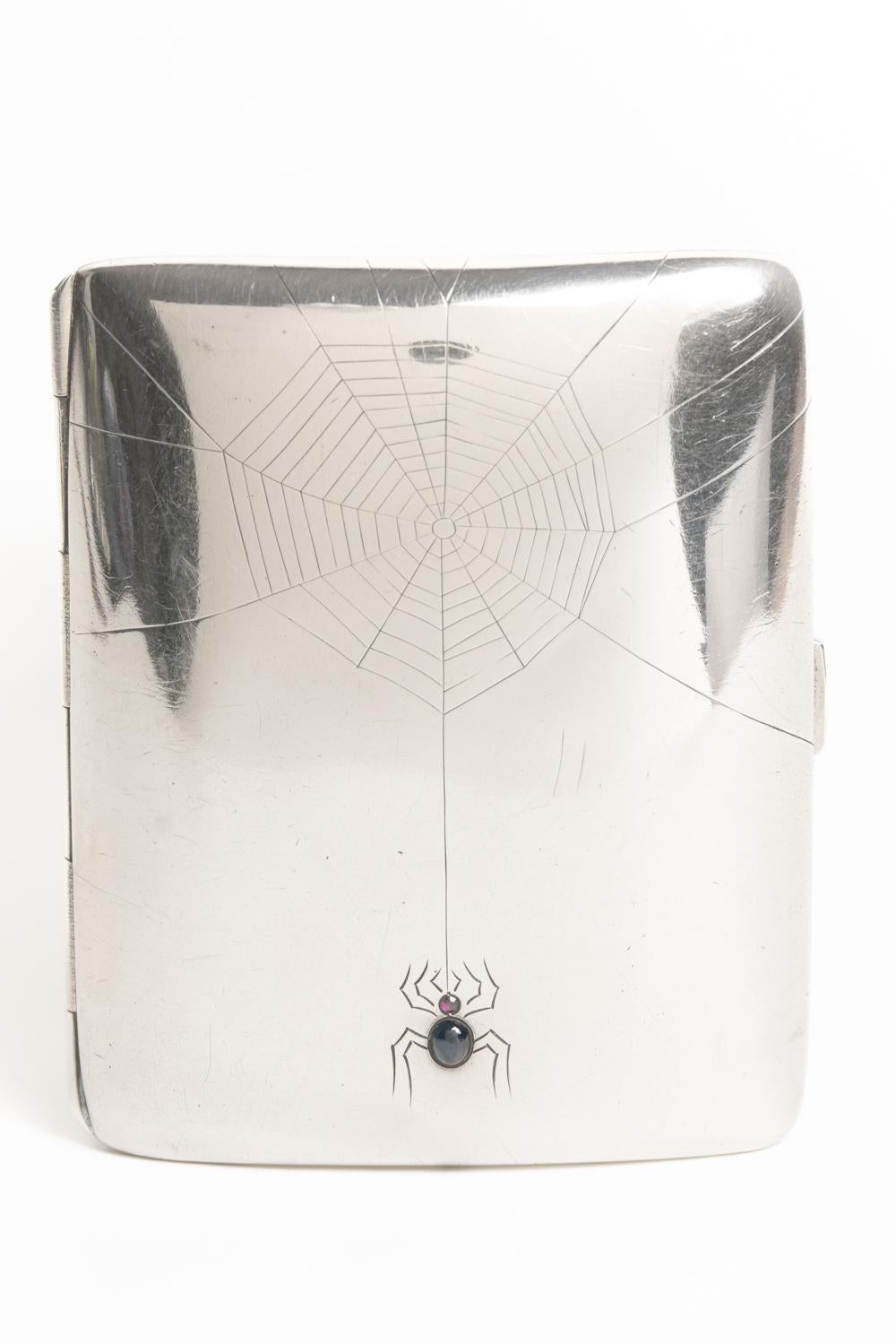 This rare and exceptional Jugendstil sterling silver cigarette case is made in silver 800/Austria circa 1900. The cigarette case has a rectangular and unusual bulbous shape and depicts an engraving of a spider and web in the front of the case. The