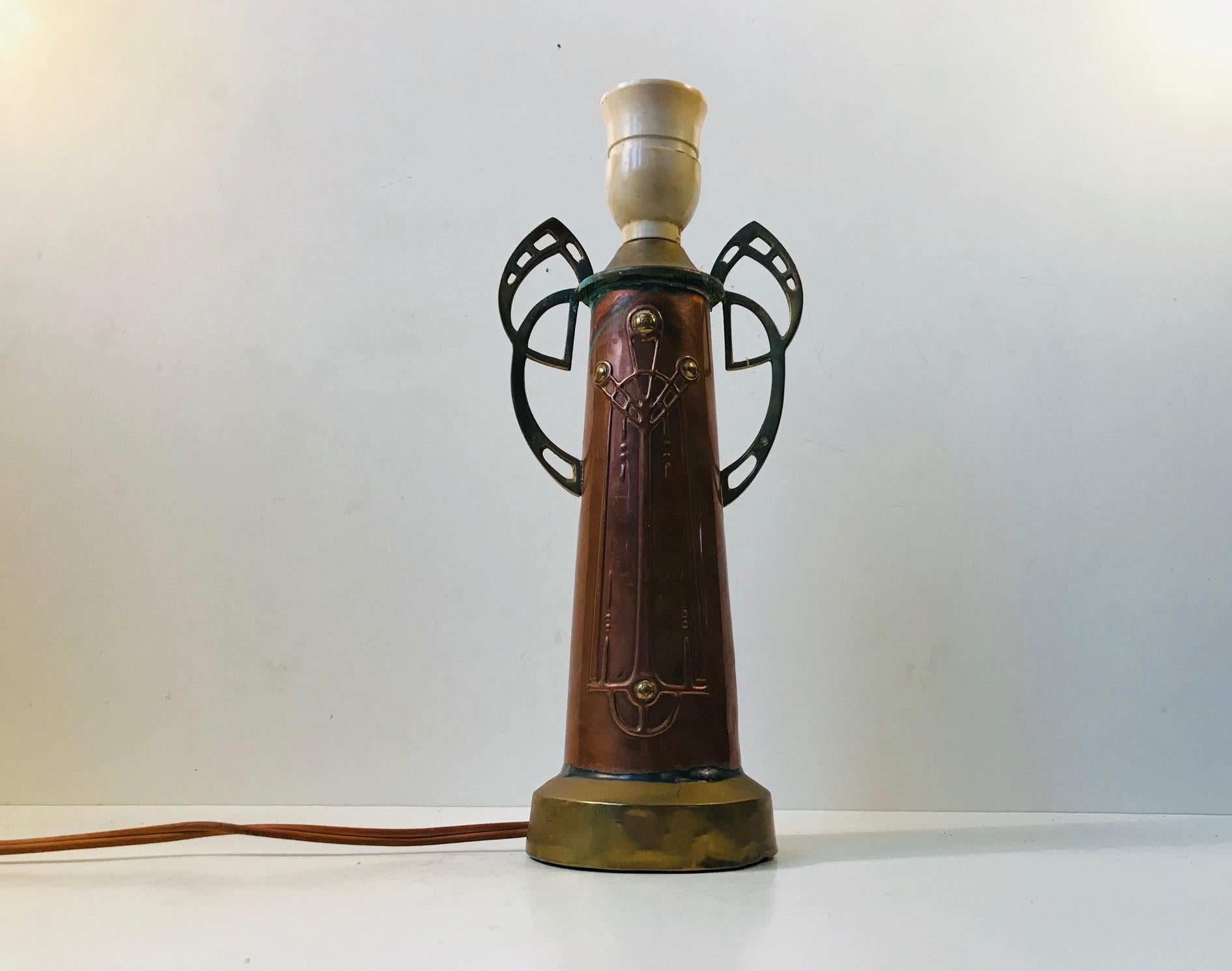 Characteristic Jugendstil table light in patinated unpolished copper and brass. It signed/inscribed to the base by an unidentified maker. Probably made in Germany during the 1910s in a style reminiscent of WMF. Please personalize with your own