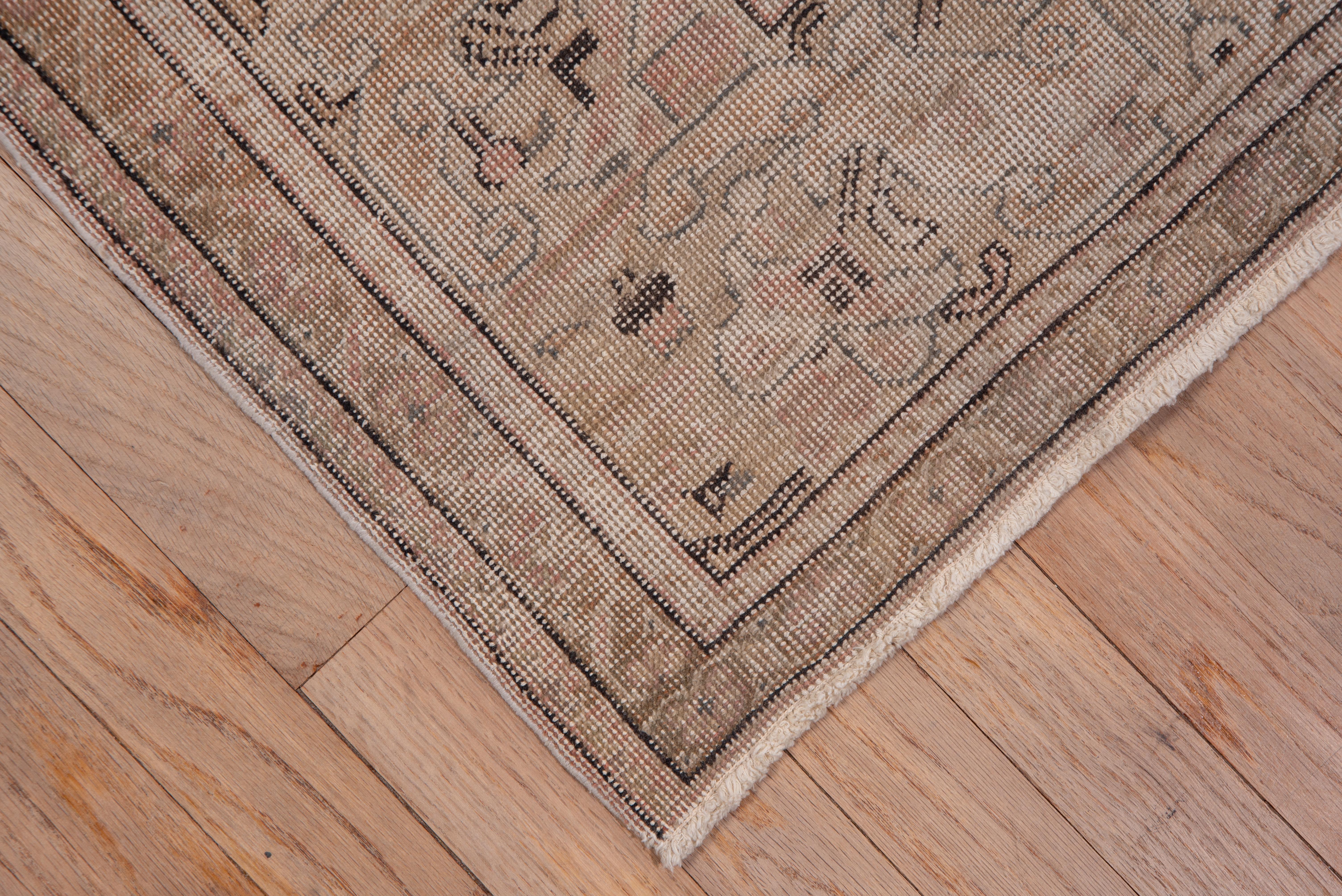 This rather distressed eastern Turkish city carpet has a Persianate design of large, angular, bent leaves, angled palmettes and a layered, ragged palmette/rosette central motif, all on a sandy ground with dark brown outlines.