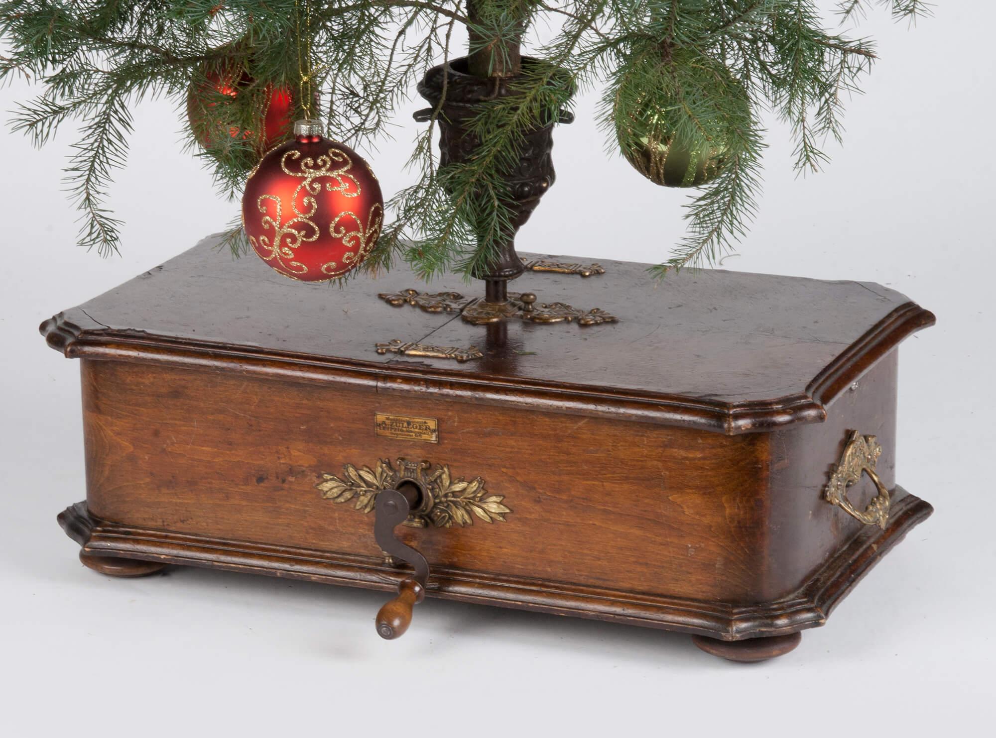 A rare and decorative German eye-catcher for the Christmas holiday. The Stand is meant to hold a tree and rotates while the music is playing. A beech veneered Kalliope box with bronze fittings. Inside the music mechanism, including 4 silver plated