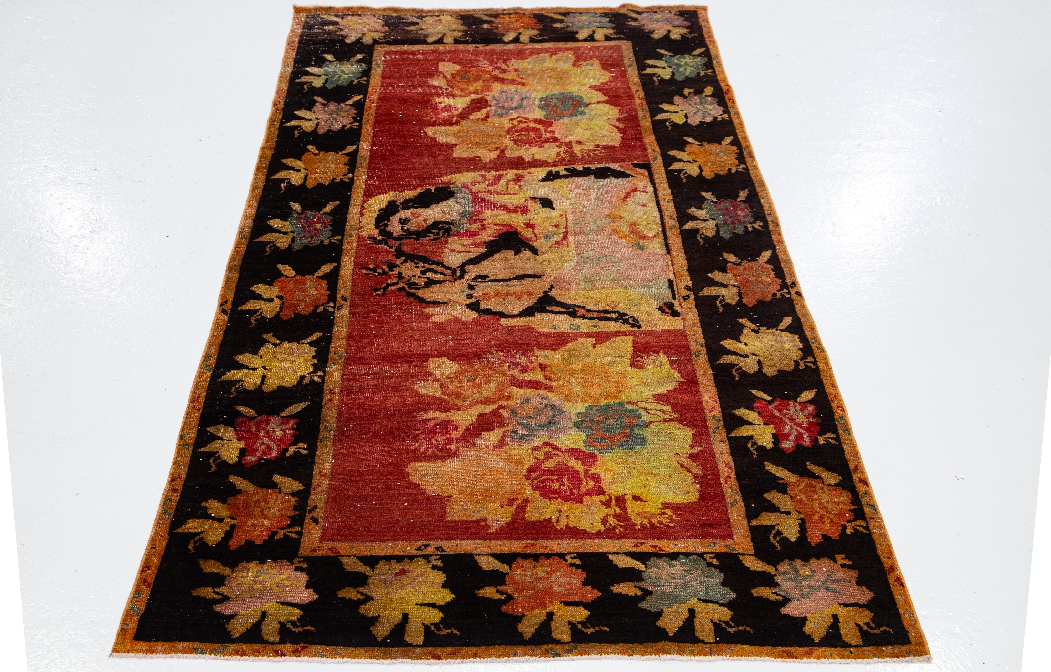 Beautiful antique Karabagh hand-knotted wool runner with a red field. This Persian runner has a brown frame and multicolor accents that feature an all-over pictorial design.

This rug measures 4'5