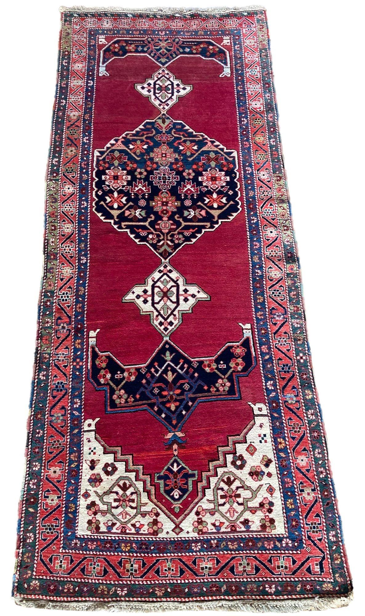 A fabulous antique Karabagh rug, handwoven in the southern Caucasus mountains of modern day Azerbaijan circa 1900. The design features an offset medallion on an open red field and terracotta border. Lovely secondary colours including a beautiful