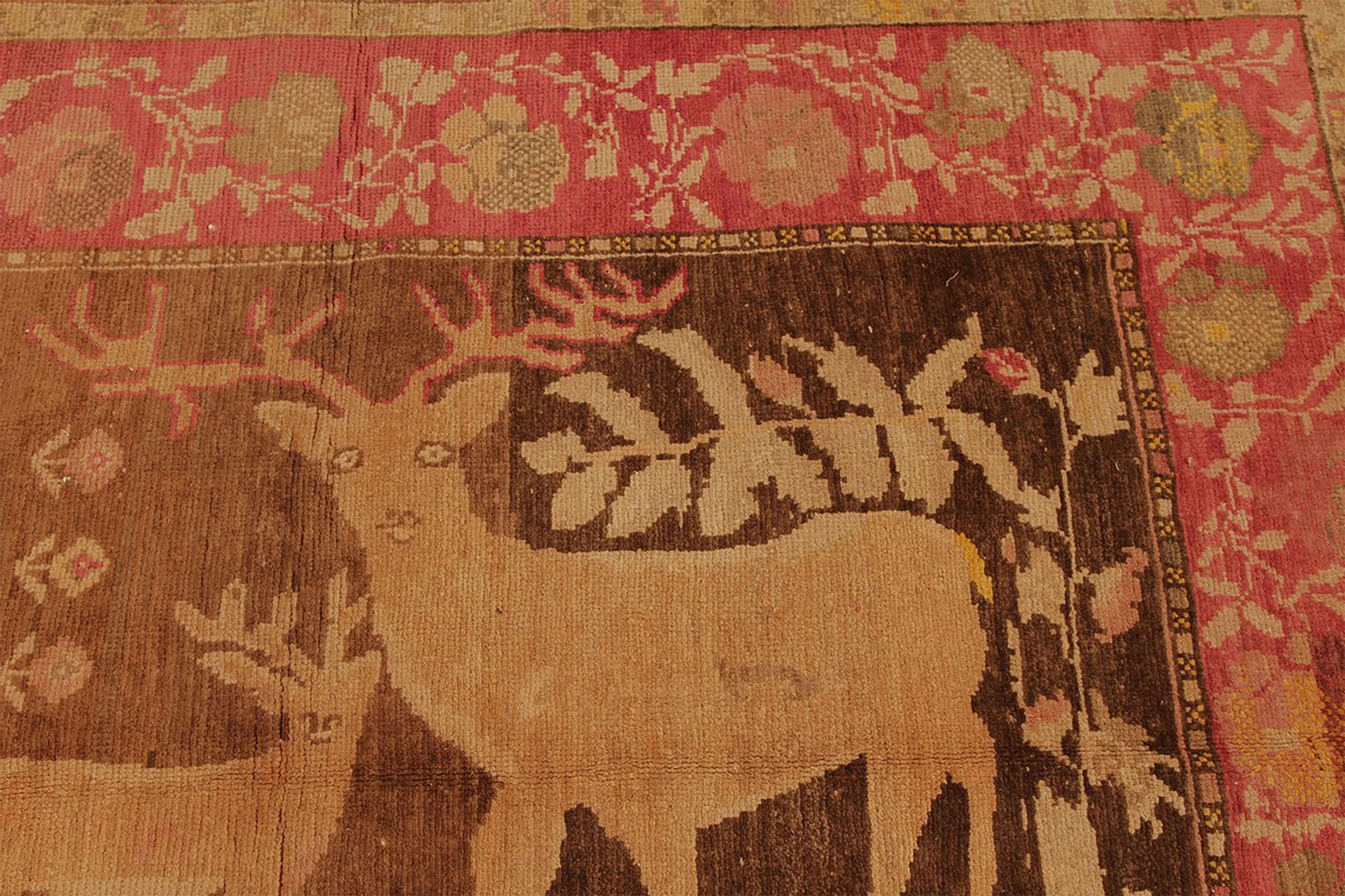 Hand knotted in Russia originating between 1890-1900, this antique Karabagh wool rug enjoys a stunning autumnal colorway complementing both the soft floral motifs and the regal deer pictorial in the border and field respectively. The light accents