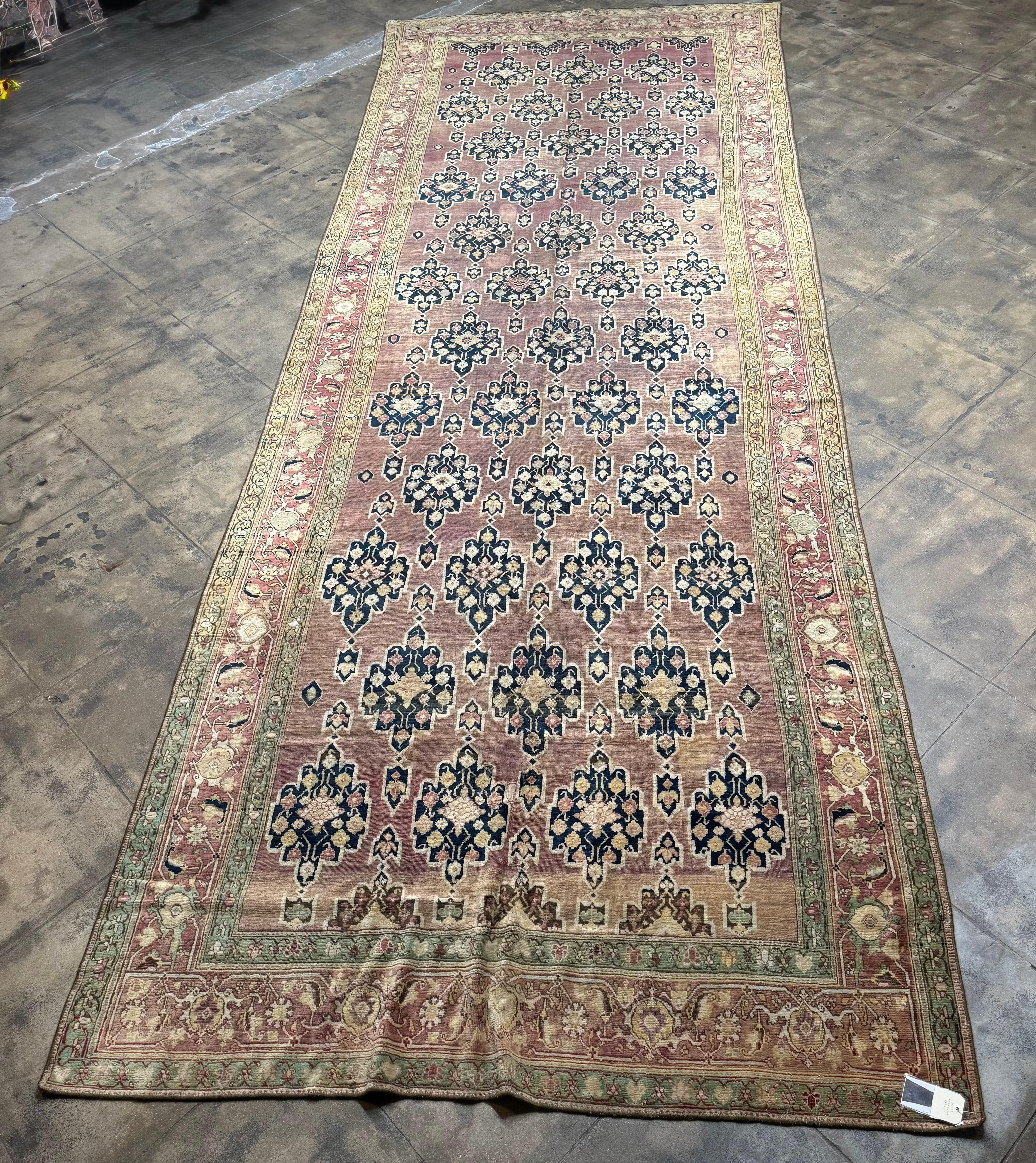 Ein exquisiter Läufer aus Karabagh aus dem 19. Jahrhundert, handgewebt um 1850 in der Kaukasusregion. Dieses Stück in Museumsqualität zeigt ein elegantes, sich wiederholendes Blumenmedaillon vor einem zartrosa Feld, umrahmt von einer kunstvollen