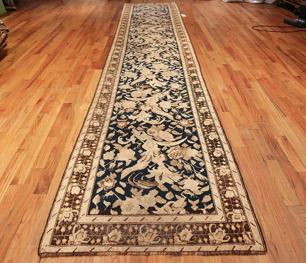 Antique Karabagh rug, origin: Caucuses, circa early 20th century. Size: 3 ft 7 in x 19 ft 3 in (1.09 m x 5.87 m)

– Floral borders decorated with accentuated floral motifs linked by a chain of alternating pomegranate fruits frame the stately