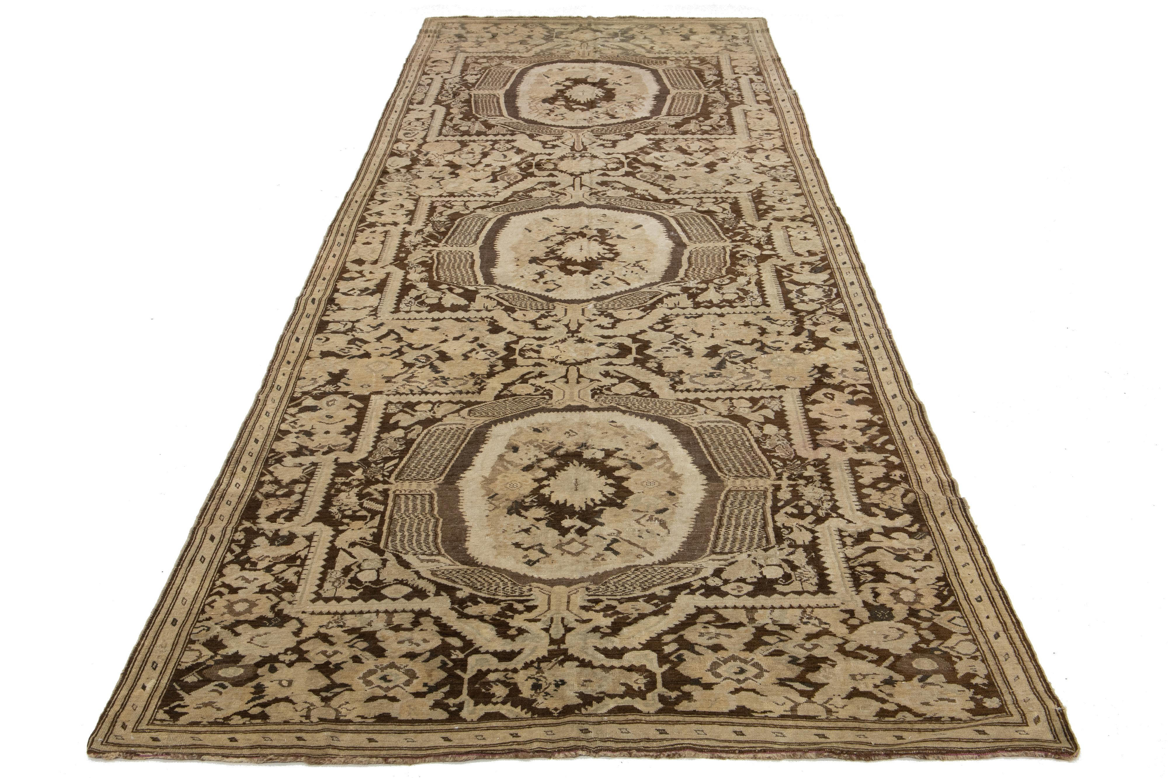 Dies ist ein wunderschöner antiker handgeknüpfter Wollteppich von Karabaugh mit einem braunen Feld. Es zeigt schöne beige und graue Akzente in einem fesselnden geometrischen Tribal-Muster.

Dieser Teppich misst 6'7
