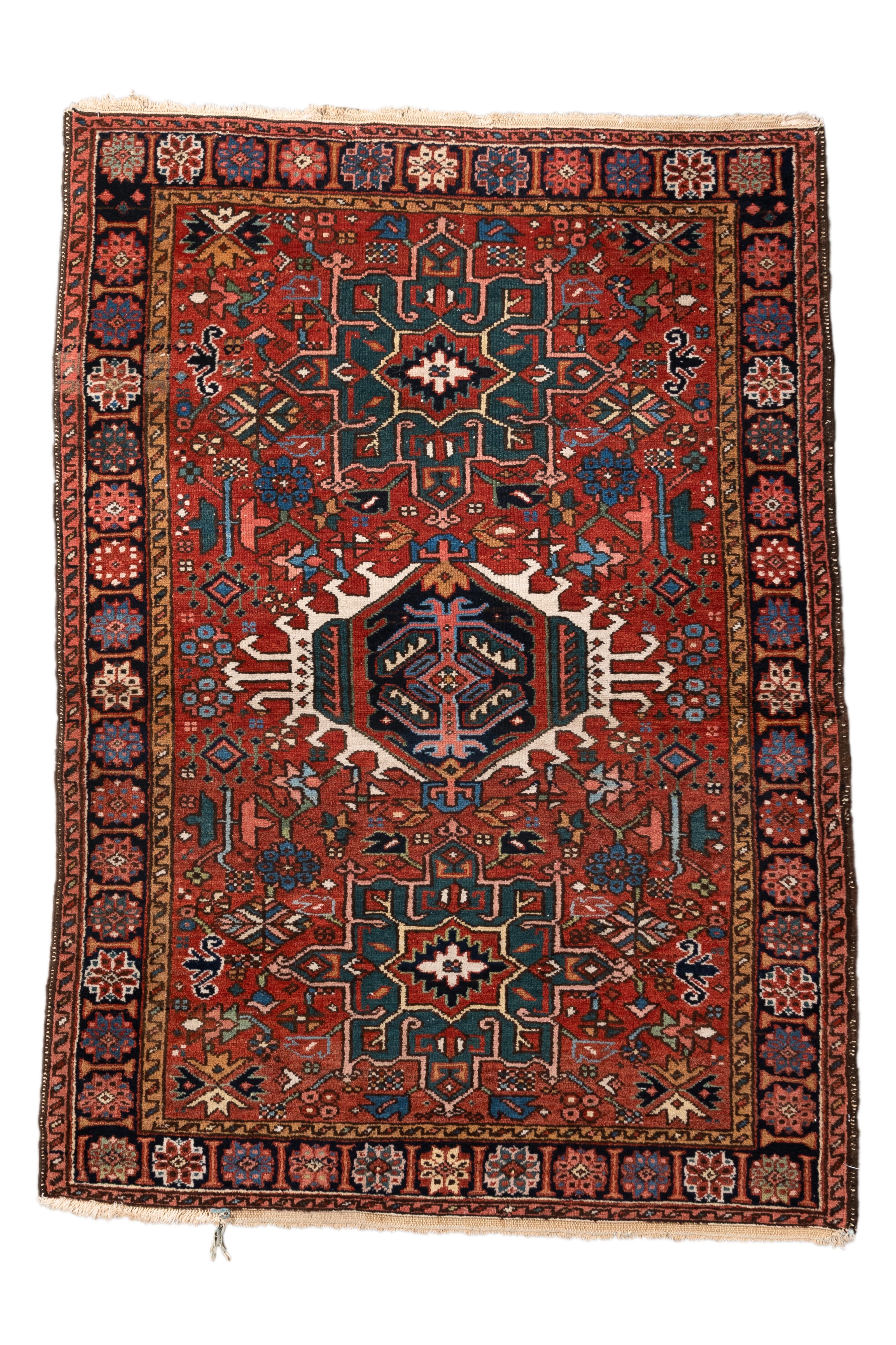  This antique Karaje rug from Northwest Persia features the classic Heriz-region triple medallion design, rendered in a vibrant palette of rust red, deep indigo, ivory, and forest green. At 3'6