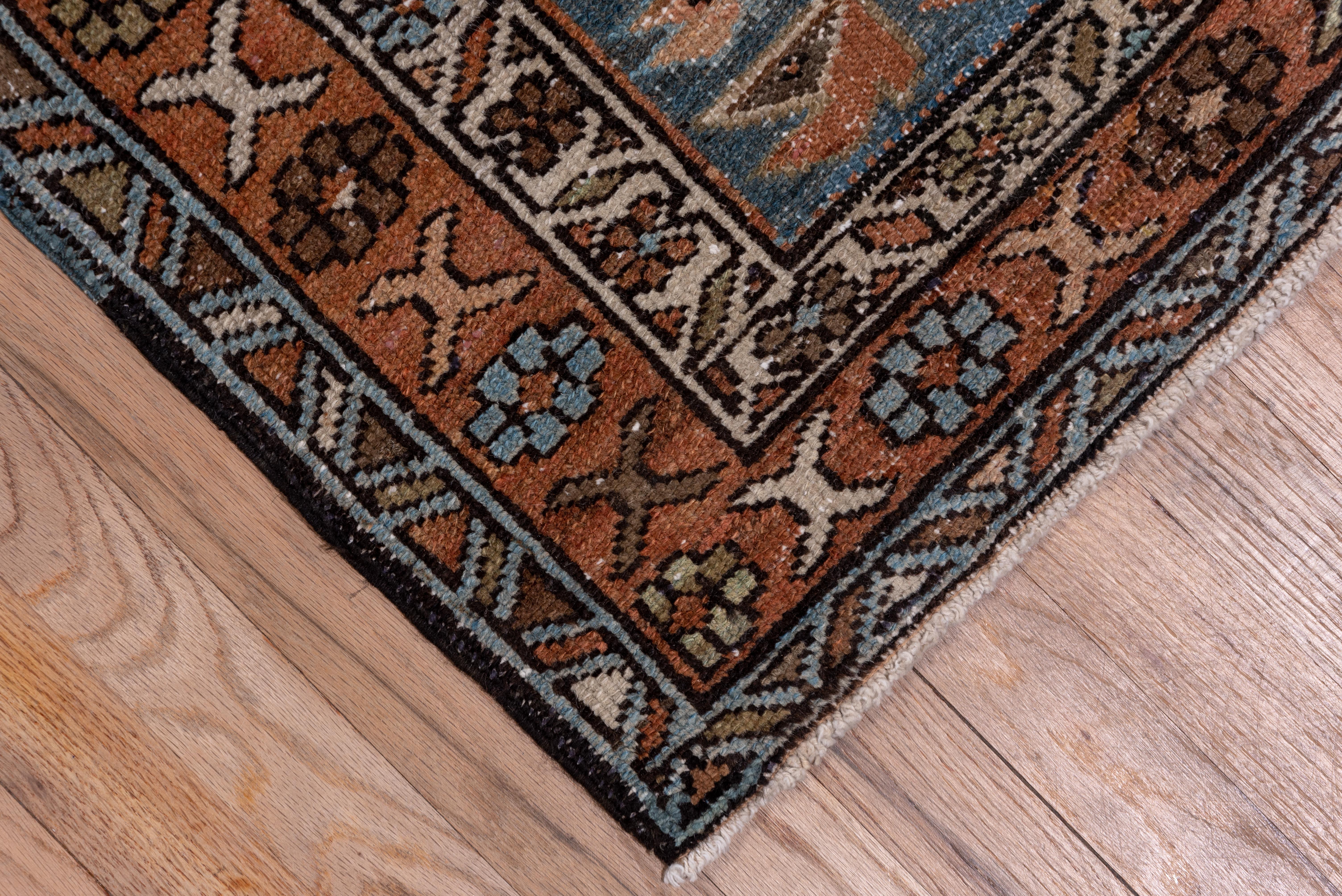 The light blue-green field of this NW Persian village runner displays the iconic Karaje octogram and hooked lozenge motives alternating, within a camel buff main border of rosettes and X's.