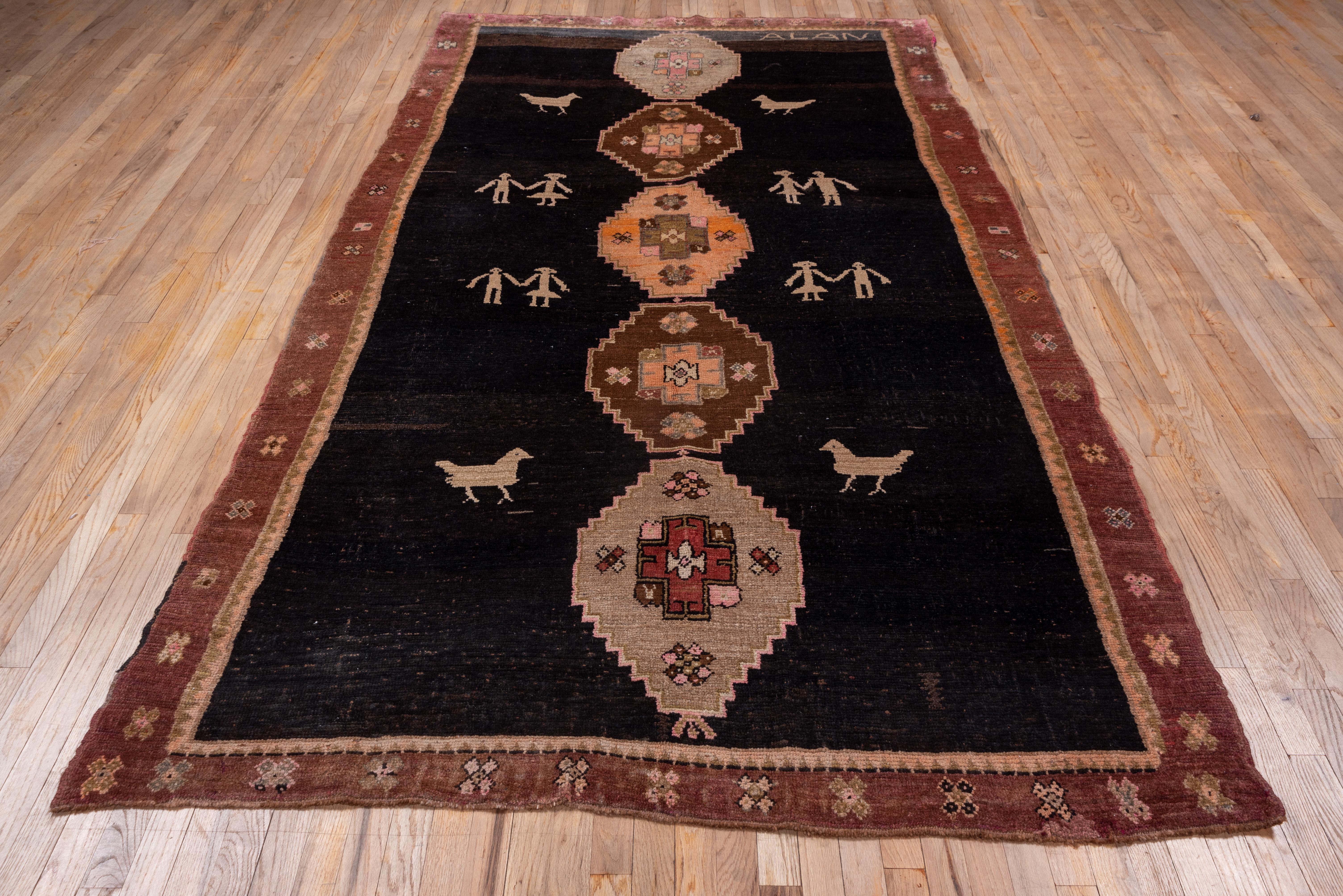 Turkish Antique Kars Rug, Black Field with Animal Motifs and People Motifs, Pink Accents For Sale