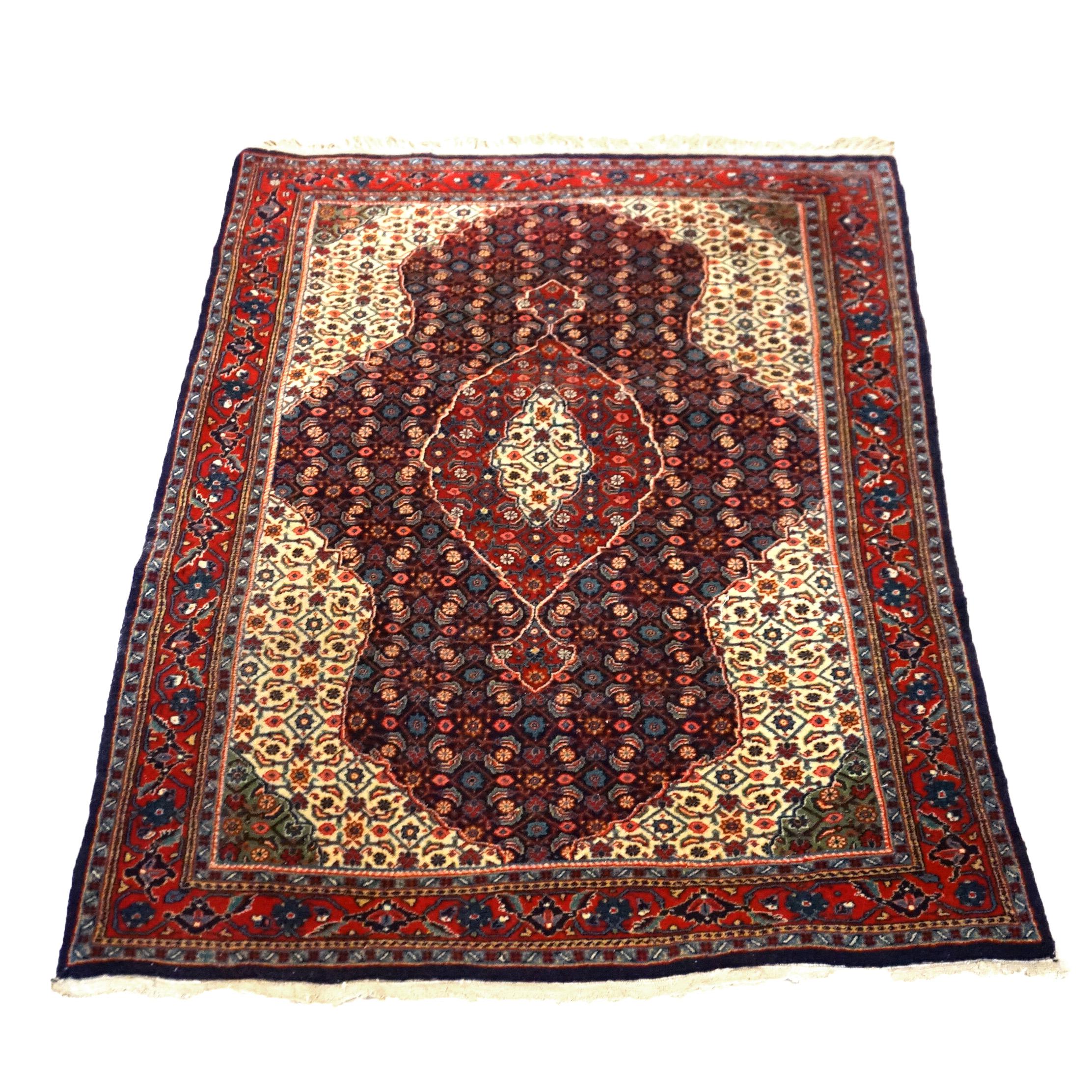 An antique Kashan oriental rug offers wool construction with central medallion and stylized foliate and floral elements, circa 1940

Measures- 68''L x 42.5''W x .5''D