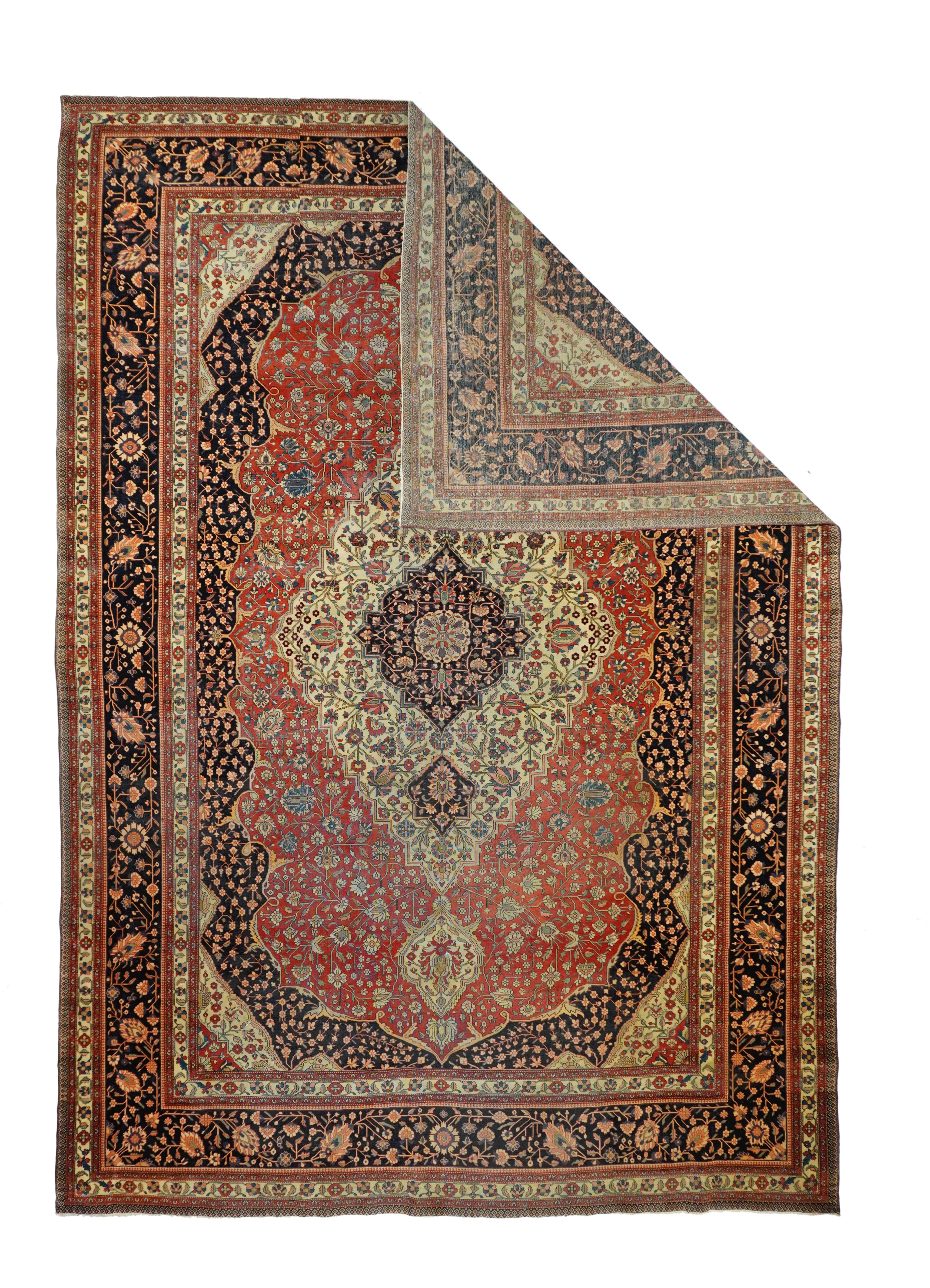 Antique Kashan rug, measures: 9' x 12'6''. From the later antique Mohtasham era, this finely woven central Persian carpet with velvety pile shows a navy millefleurs field enclosing a shaped red cartouche-form subfield edged with straw forked