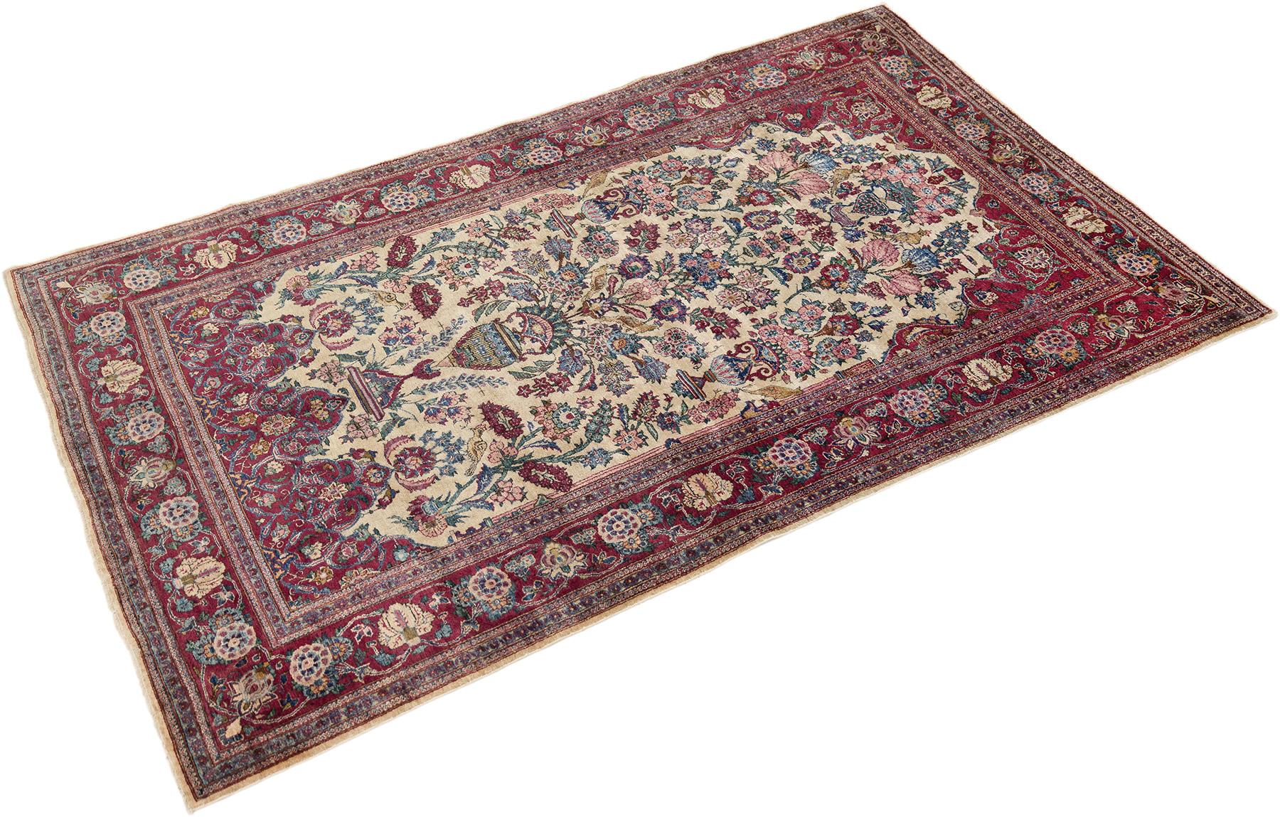 Hand-knotted Kashan rug, woven in Central Iran circa 1900.

This exquisite antique Kashan rug features a finely detailed vase design with graceful floral arrangements and scrolling vines set against an ivory field. Accented by shades of deep red,