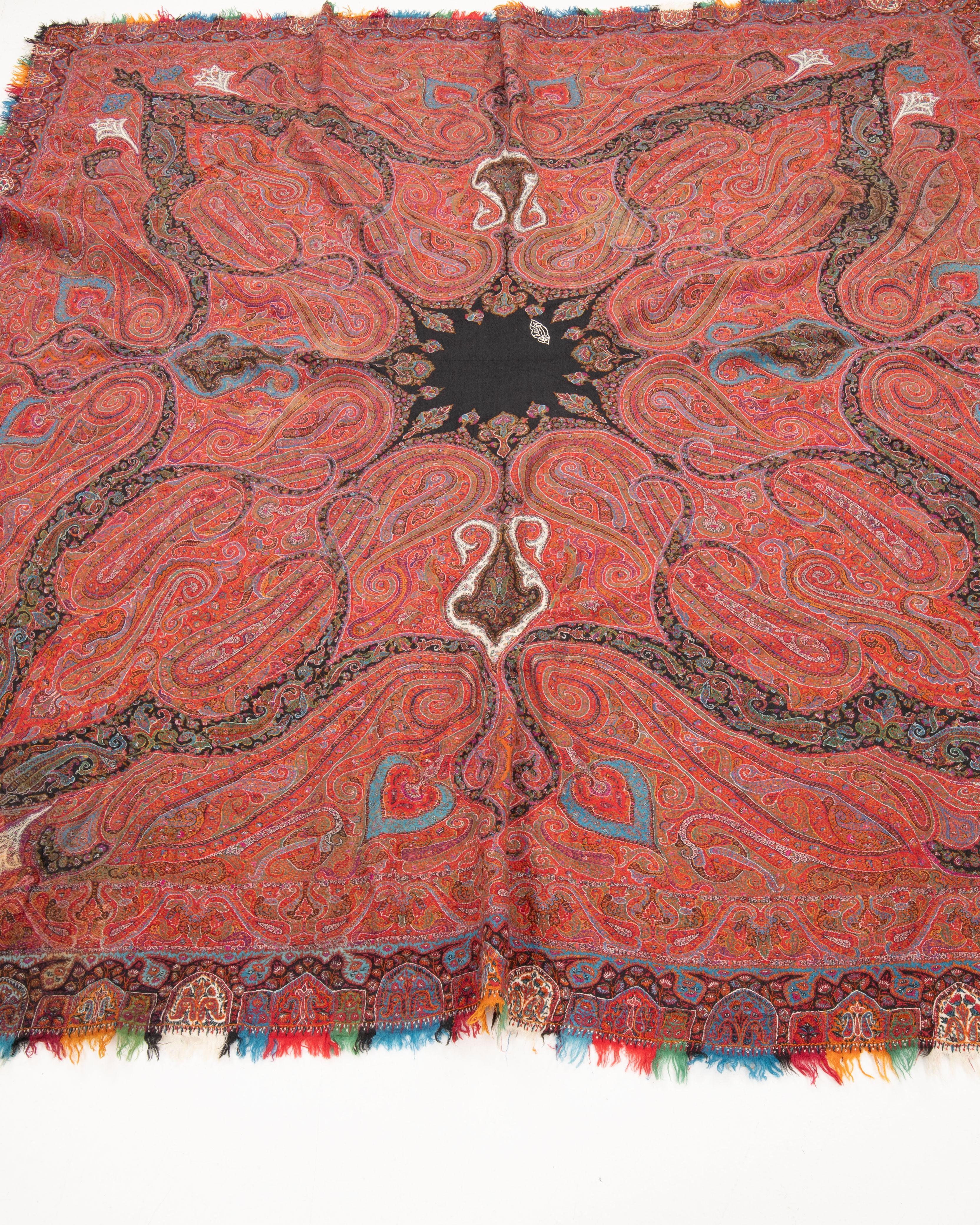 A  square Kashmir shawl, dating to the mid–19th century, finely handwoven in wool with an intricate allover boteh (paisley) design. The composition features large, sweeping paisleys radiating from a central medallion in deep black, framed by a