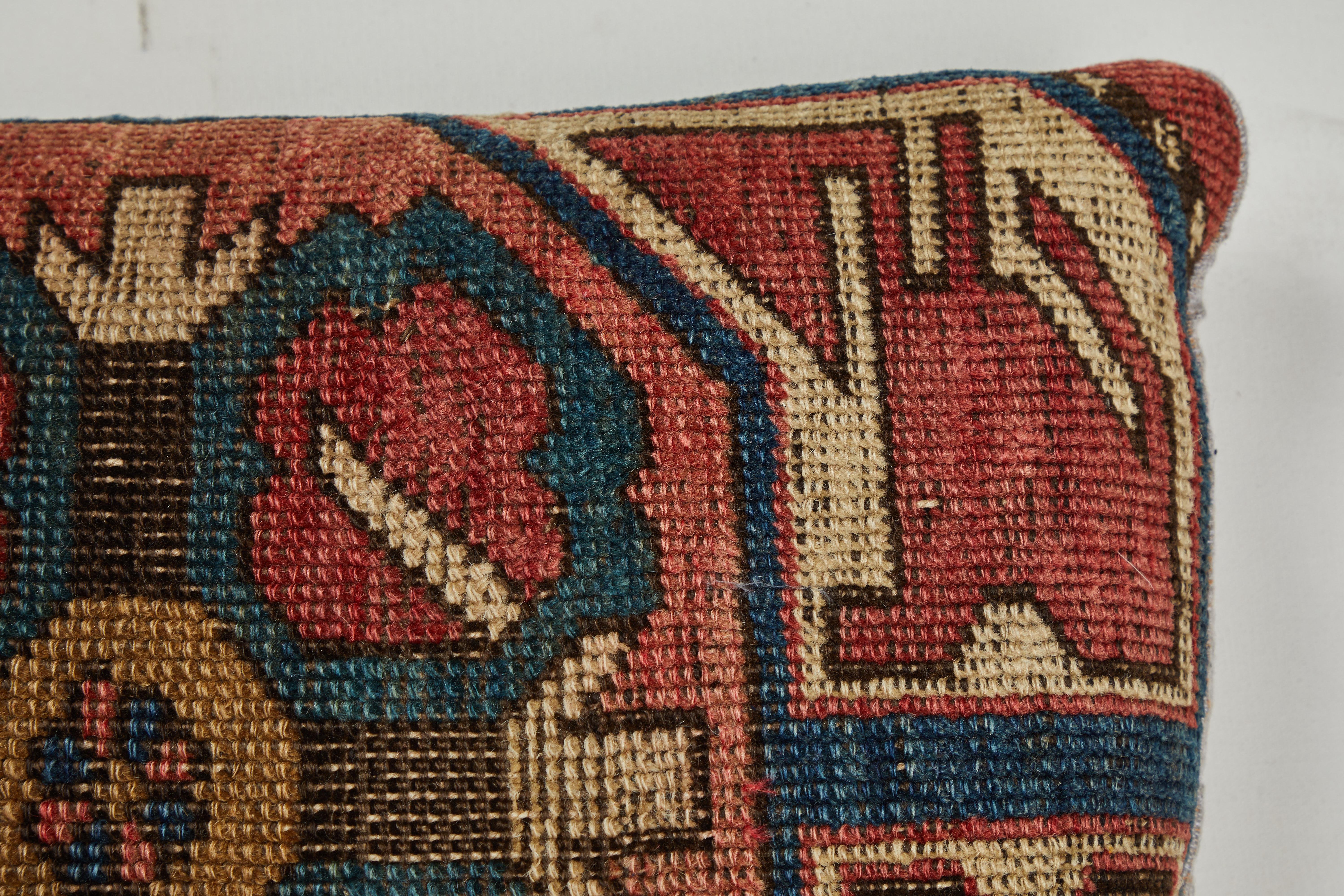 Rug fragment showing centre medallion of Kazak Caucasian tribal rug. Backed with hand woven Indian khadi cotton. Zipper closure across back and feather and down fill.