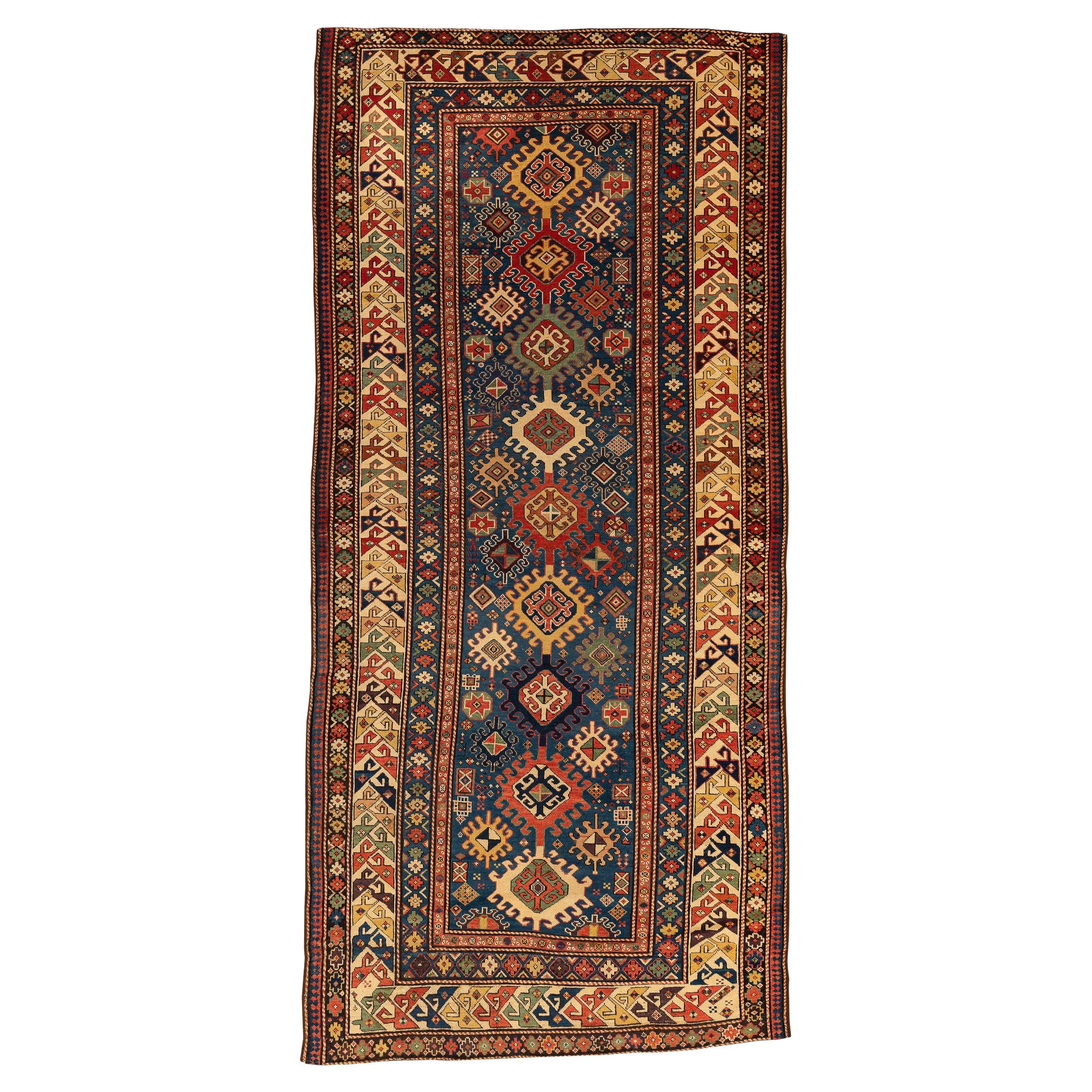 Kazak – Central Caucasus

Classic Kazak rug with ten serrated diamond-shaped medallions lined up in the centre of the blue field. Surrounding the more oversized medallions, small serrated medallions, lozenges, flowers, bushes, and other geometric