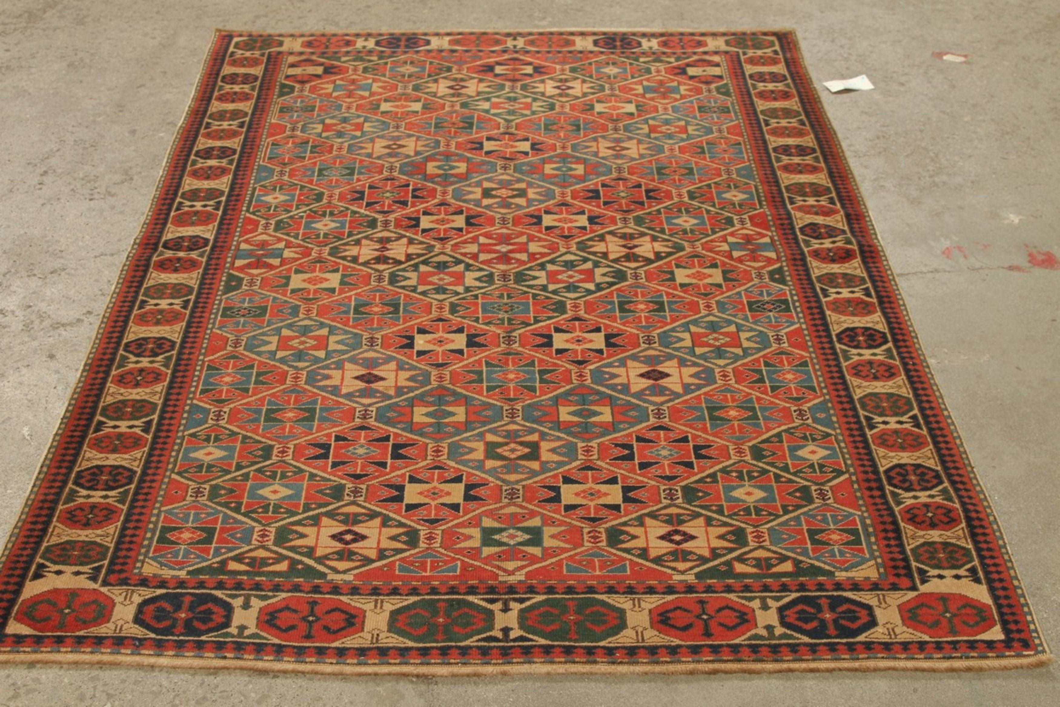 Dieser atemberaubende handgeknüpfte Teppich aus der Kaukasusregion verkörpert die reichen Traditionen der Nomadenstämme des 19. Jahrhunderts, wie sie in Aserbaidschan oder Dagestan herrschen. Die kühnen geometrischen Muster und die leuchtenden