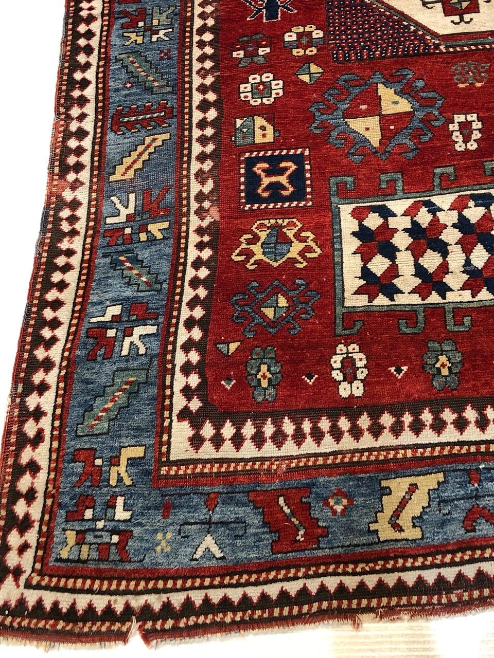 Ce tapis Kazak Karachov ancien est un superbe exemple de tissage caucasien de la fin du XIXe siècle. Il se distingue par ses médaillons géométriques audacieux et ses teintures naturelles brillantes. Tissé à la main par des artisans tribaux de la