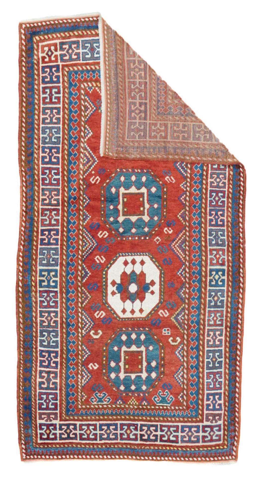 Tapis Kazak antique 3'10'' x 7'7''. Ce tapis long caucasien du sud-ouest, qui n'est pas un Kuba, présente un champ rouge garance avec quatre octogones empilés alternant en bleu moyen et crème, avec une bordure intérieure implicite en triangle