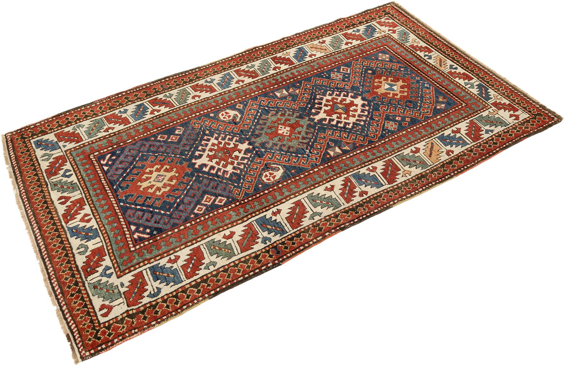 Tapis kazak noué à la main, tissé en Arménie vers 1900.

Ce tapis Kazak ancien présente un motif géométrique audacieux composé de médaillons en forme de diamant et de motifs stylisés dans des tons vibrants de rouge, de bleu et d'ivoire. La