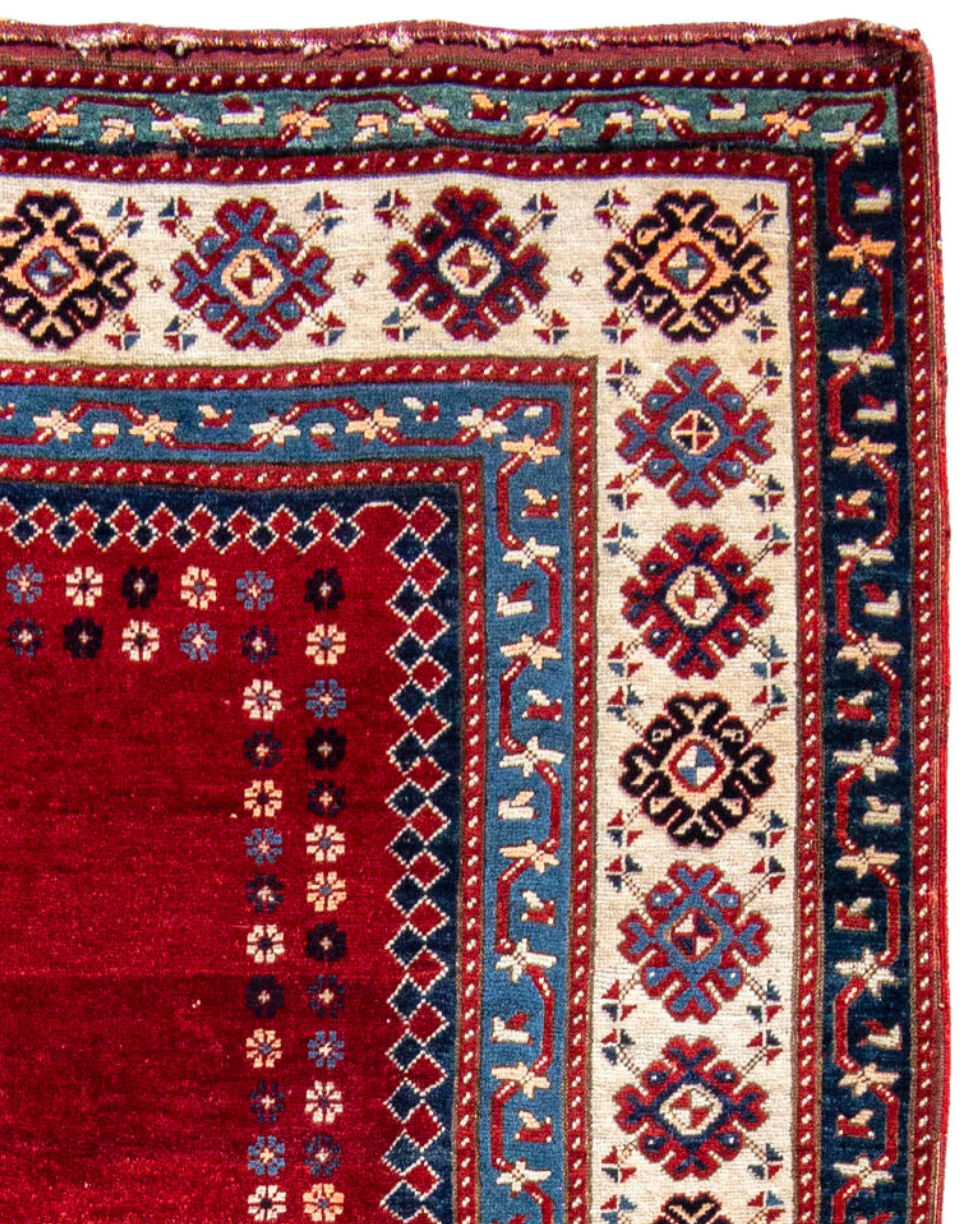 Antique Kazak Rug, Late 19th Century

With an empty red field with multi-colored snowflake-like motif floating on the edges, framed by the blue/green reciprocal designed border, this rug catches the eye, more so than if more design was immediately