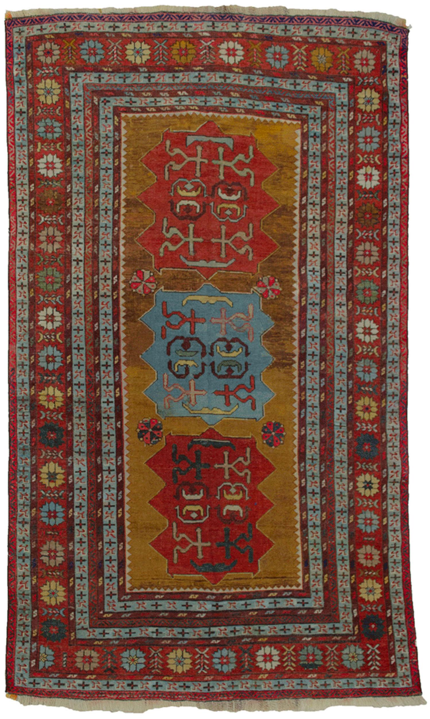 Rare antique Kazak rug. This piece is unusual in so many ways. The mustard ground colour is decorated with three unusual medallions  and framed with multiple guard borders and a geometrical rose border. The overall effect is a warm feeling that is
