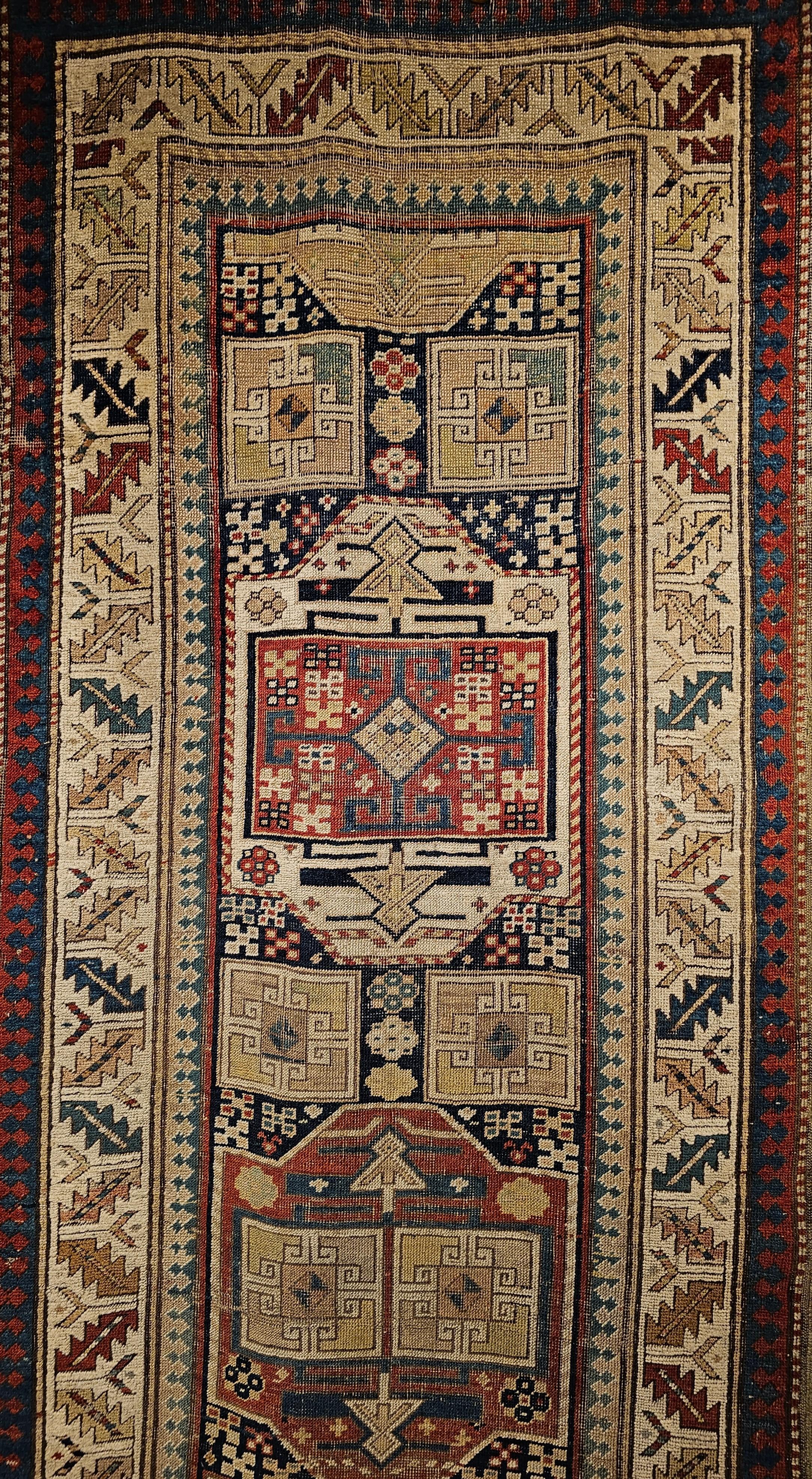 A triple medallion Karachov Kazak runner from the Caucasus region woven in the 4th quarter of the 1800s. The beauty of the rug is in having three large medallions each covering around one-third of the field and each having its own design and color