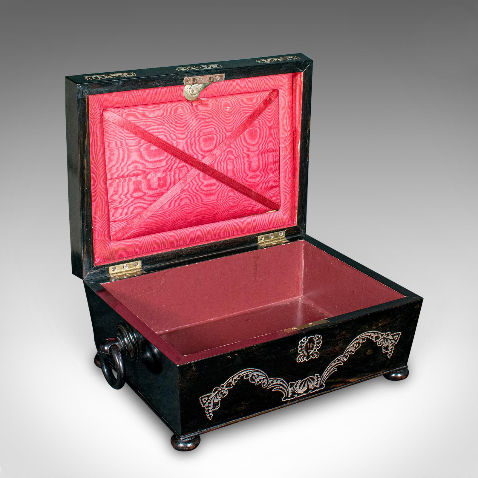
Se trata de una caja de recuerdos antigua. Un estuche de papelería inglés, con incrustaciones de Coromandel, del periodo de la Regencia, hacia 1830.

Atractiva forma de sarcófago con un acabado incrustado de buen gusto
Muestra una deseable pátina