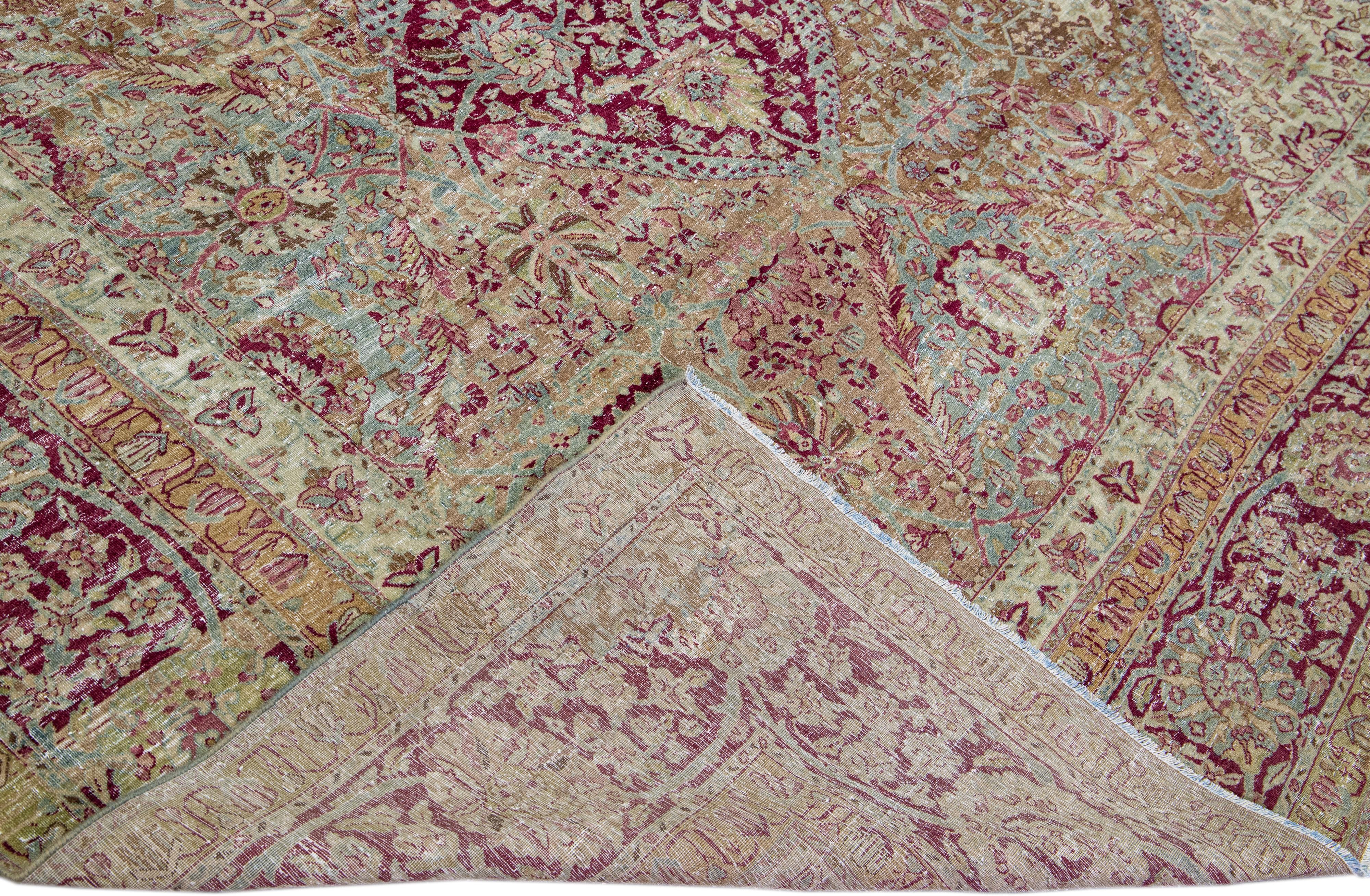 Beautiful antique Kerman hand-knotted wool rug with a brown field. This Kerman rug has a pink and blue accent in a gorgeous all-over floral pattern design.

This rug measures: 12'4