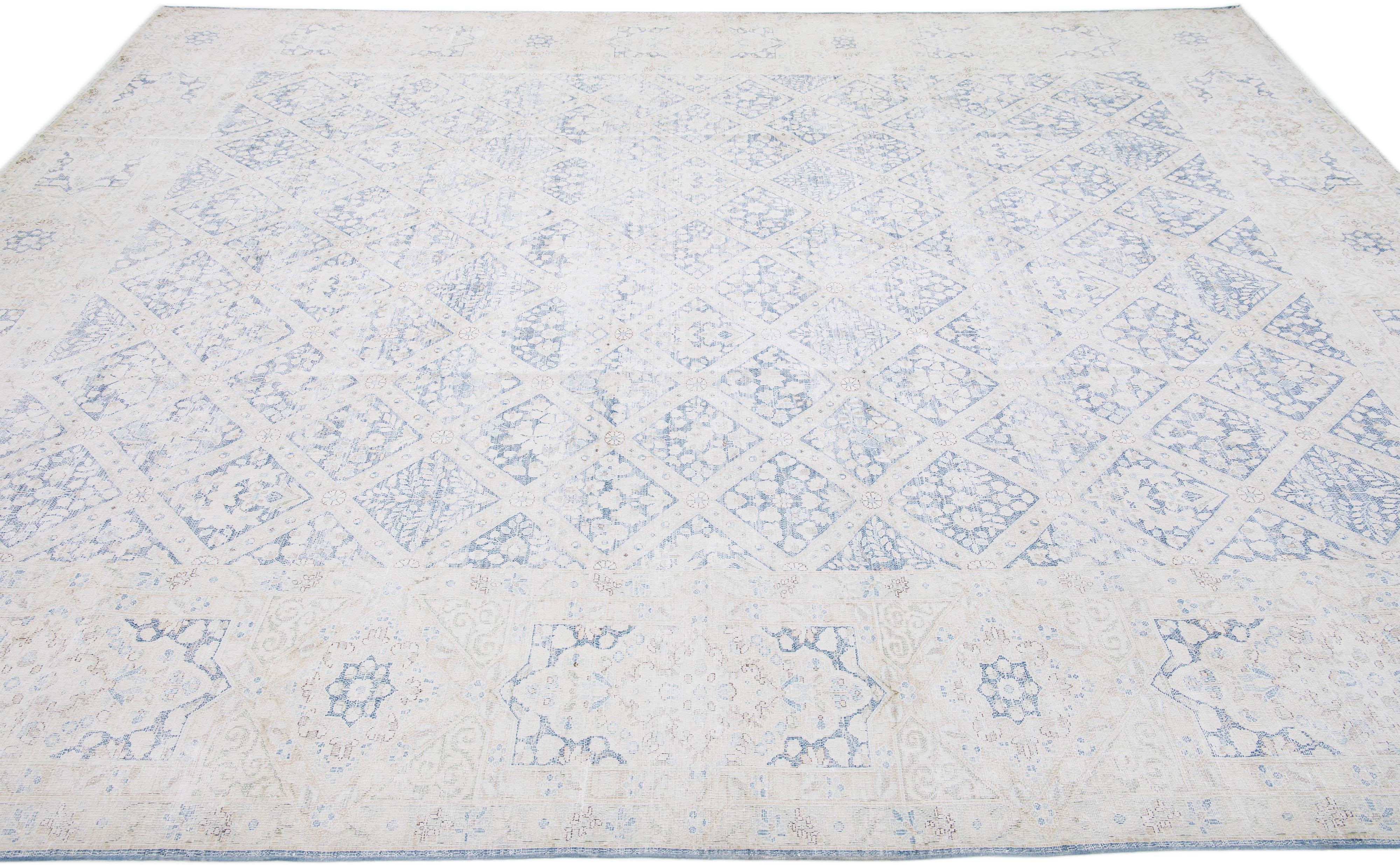Beautiful antique Kerman hand-knotted wool rug with a beige field. This Persian rug has blue accents in a gorgeous all-over floral pattern design.

This rug measures: 9'8