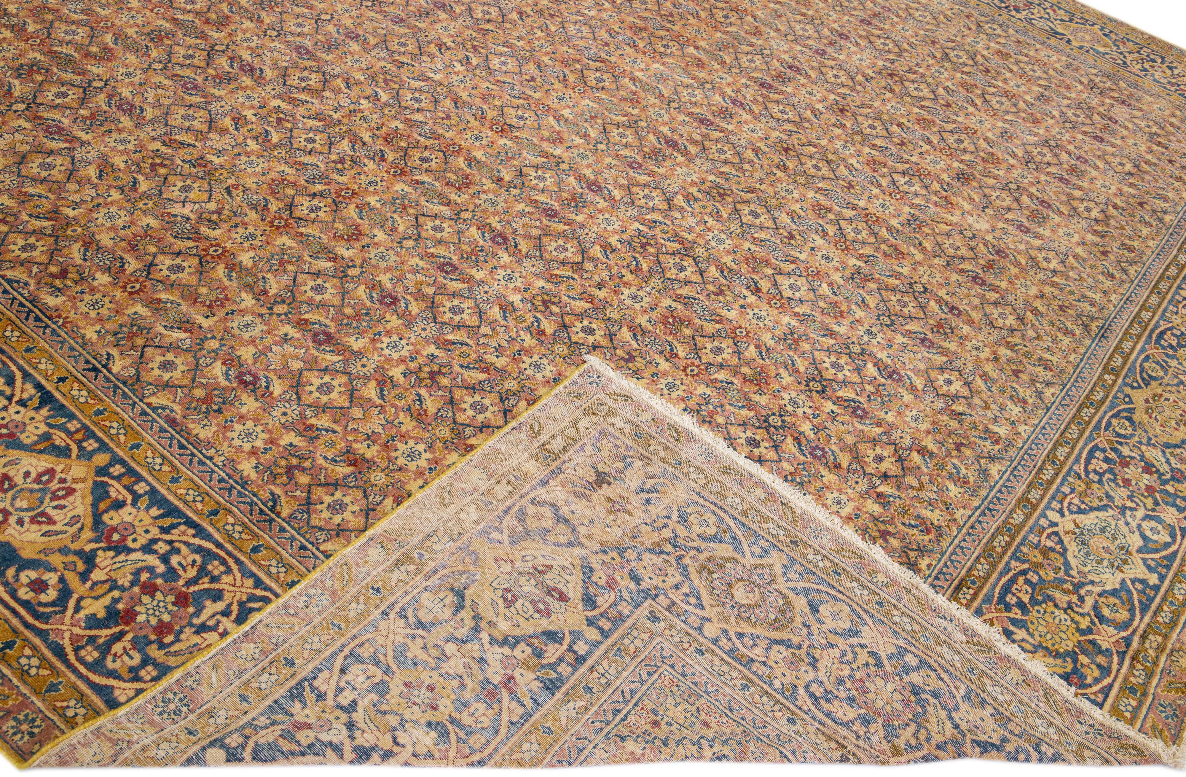 Beautiful antique Kerman hand-knotted wool rug with a tan field. This Persian rug has pink, blue, goldenrod, and red accents in a gorgeous all-over floral pattern design.

This rug measures: 14' x 18'.

Our rugs are professional cleaning before