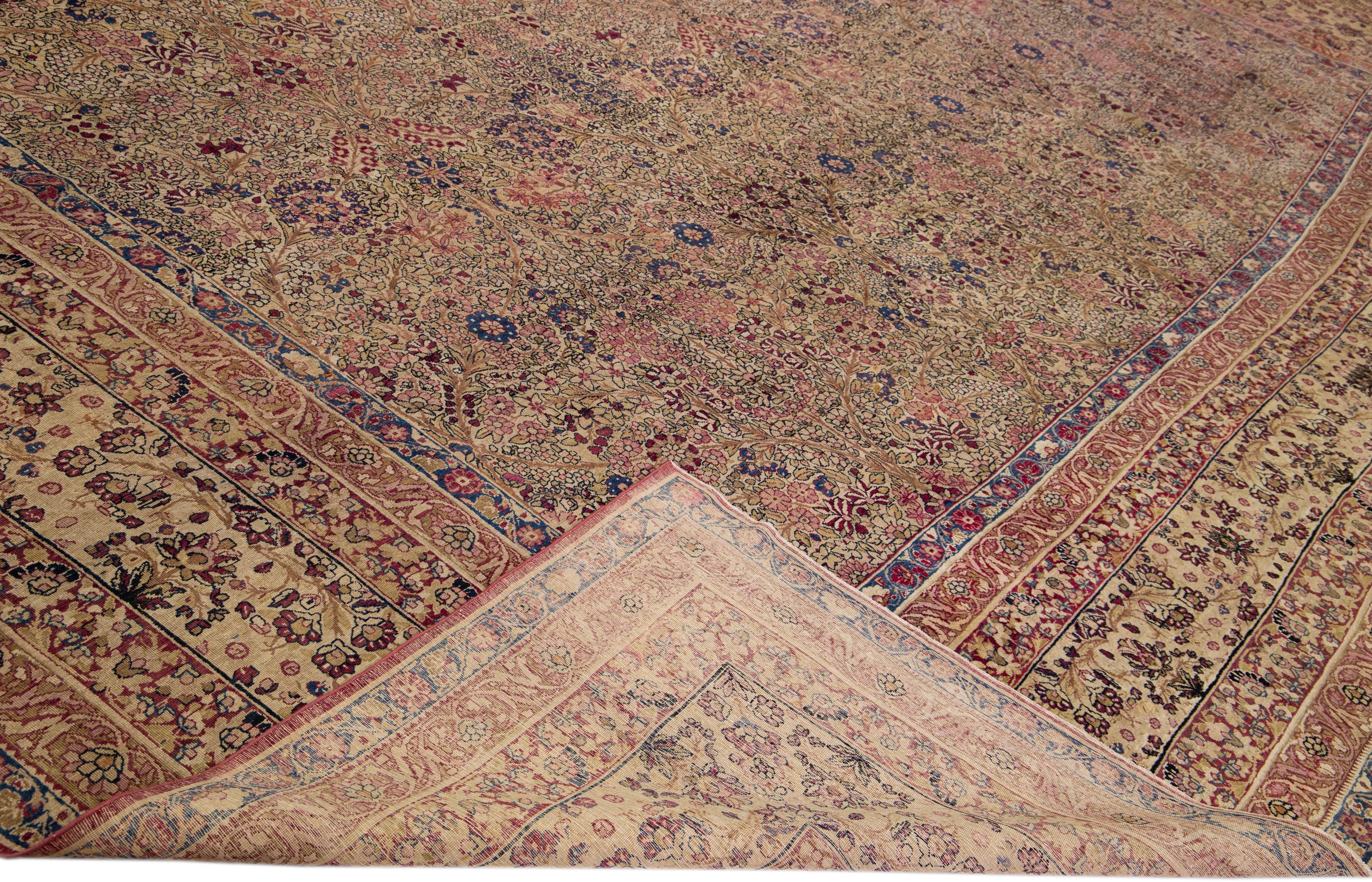 Magnifique tapis ancien en laine nouée à la main de Kerman avec un champ beige. Ce tapis persan présente des accents multicolores dans un magnifique motif floral de jardin.

Ce tapis mesure : 17'4