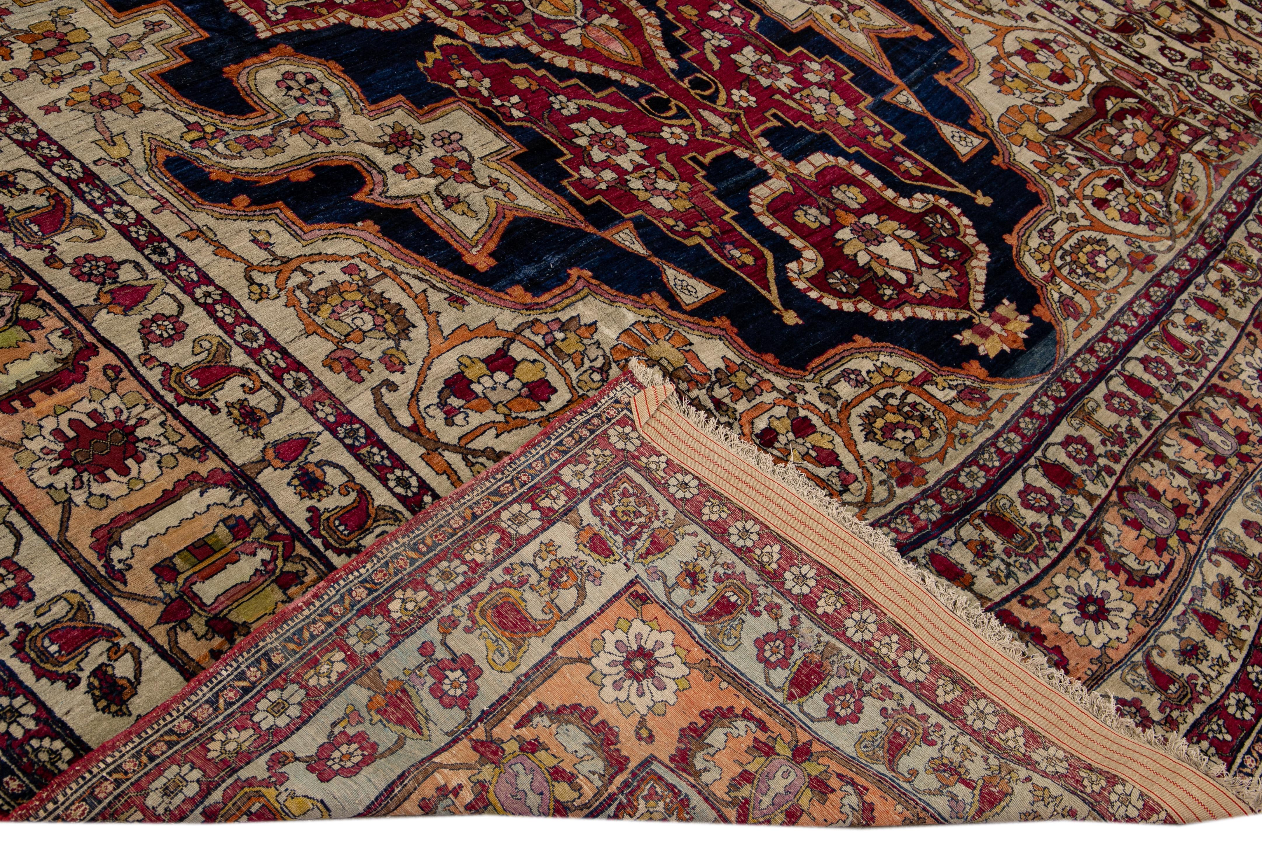Beautiful Antique Kerman hand-knotted wool rug with the blue and beige field. This Persian rug has a tan frame and multicolor accents in a gorgeous all-over medallion floral design. 

This rug measures: 10'8