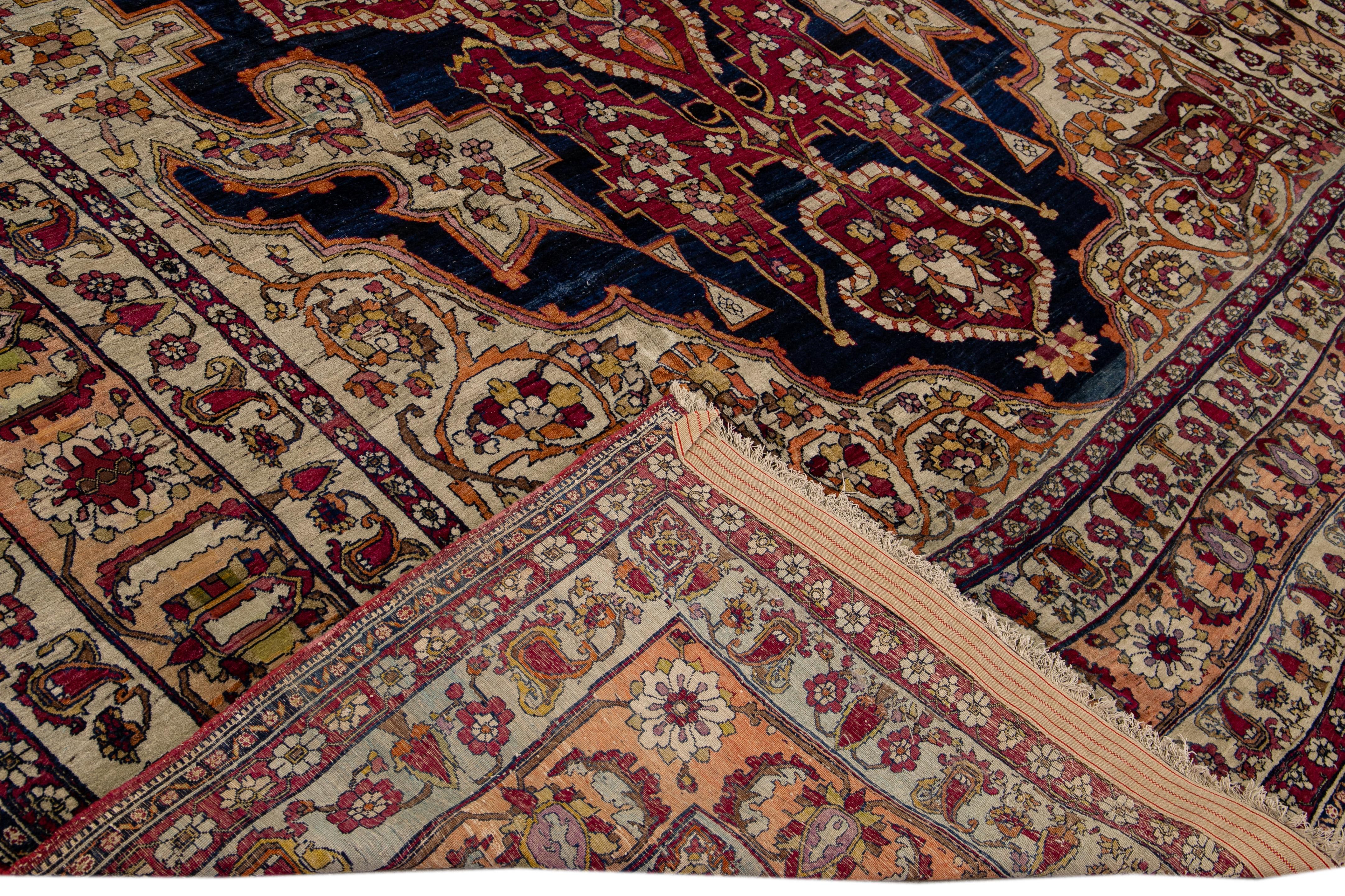 Preciosa alfombra antigua Kerman de lana anudada a mano con el campo azul y beige. Esta alfombra persa tiene un marco tostado y detalles multicolores en un precioso diseño floral de medallón. 

Esta alfombra mide 10'8