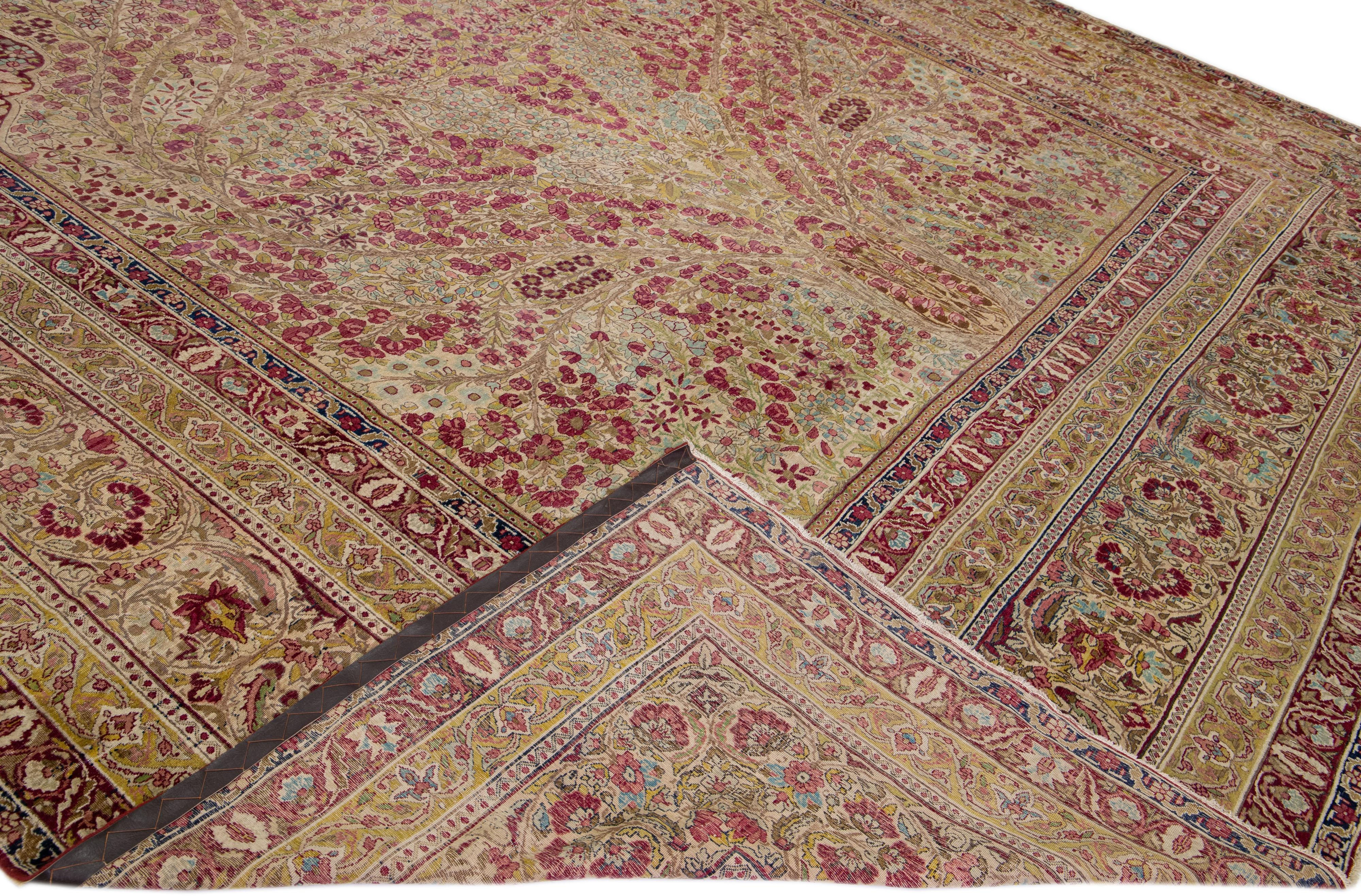 Beautiful antique Kerman hand-knotted wool rug with a beige and rose field. This Persian rug has a designed frame and multicolor accents in a gorgeous all-over rosette pattern design.

This rug measures: 14'3