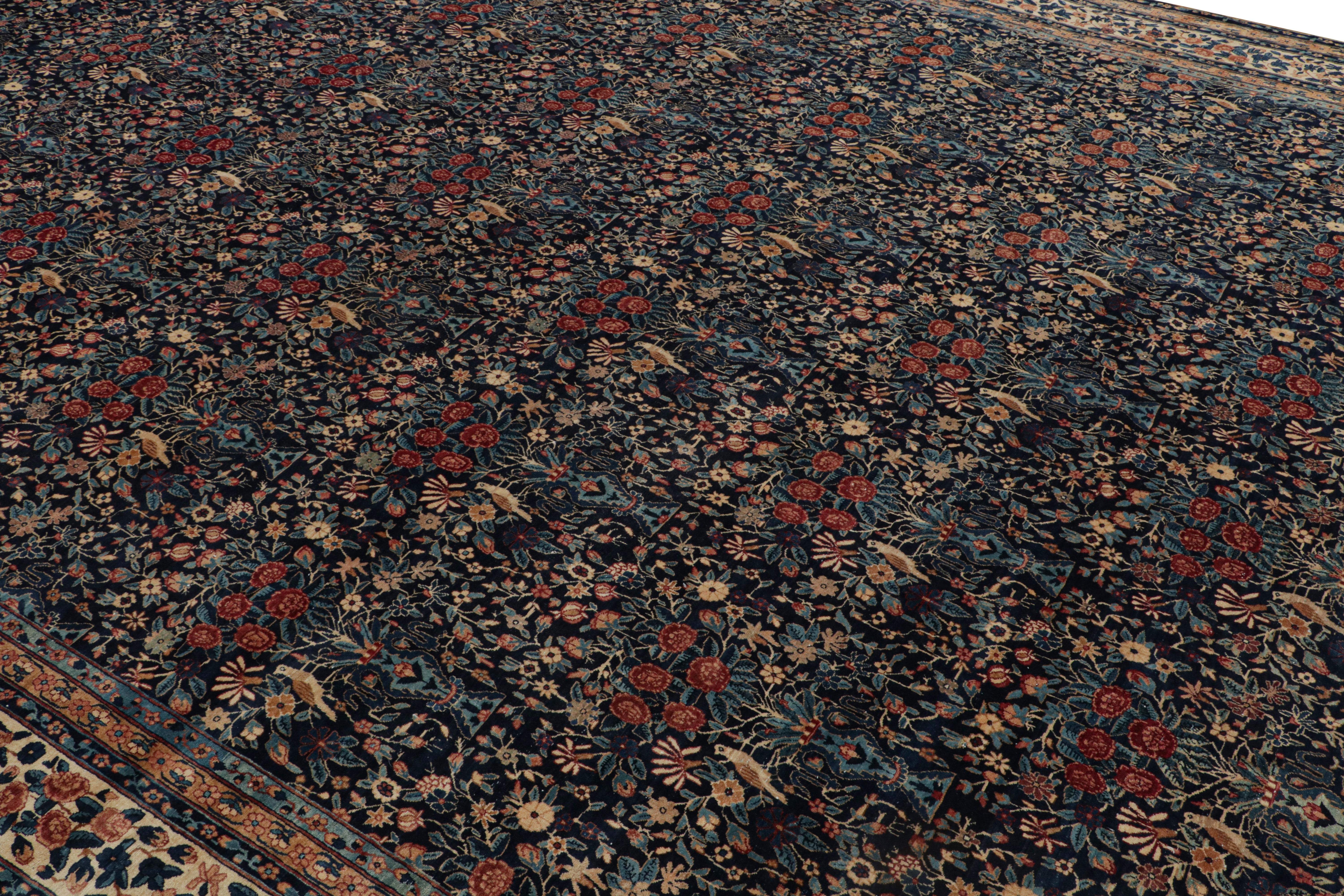 Este antiguo persa Kerman Lavar tiene un estampado floral integral de estilo tradicional. De 1910 a 1920, las numerosas variantes de flores en el campo representadas colgando de jarrones verdes y azules, son un elemento básico de los diseños de