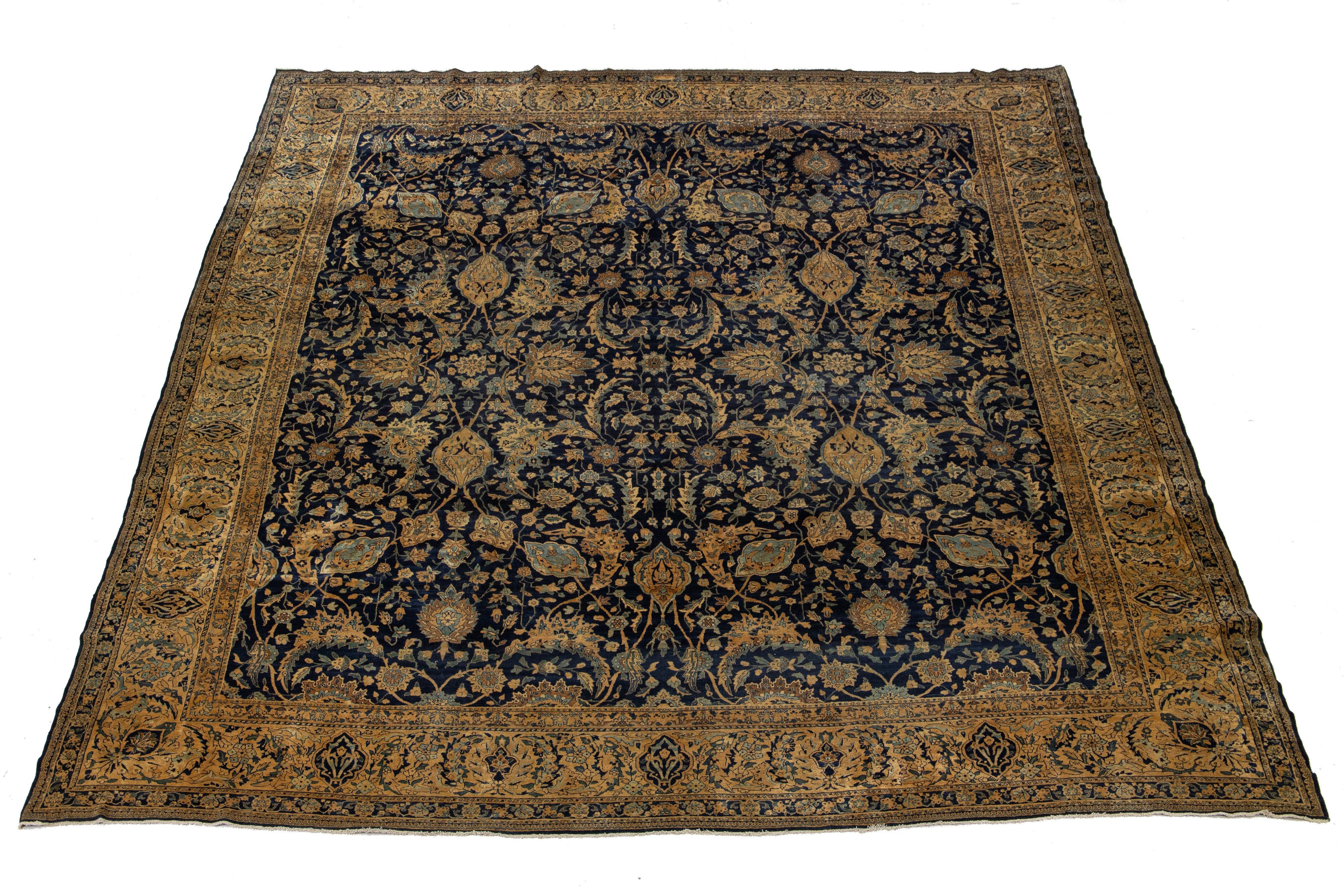 Ce grand tapis en laine noué à la main est une superbe antiquité des années 1900. Son captivant design floral bleu clair et havane danse gracieusement sur un riche champ bleu foncé, ce qui en fait un ajout intemporel à n'importe quel espace.

Ce