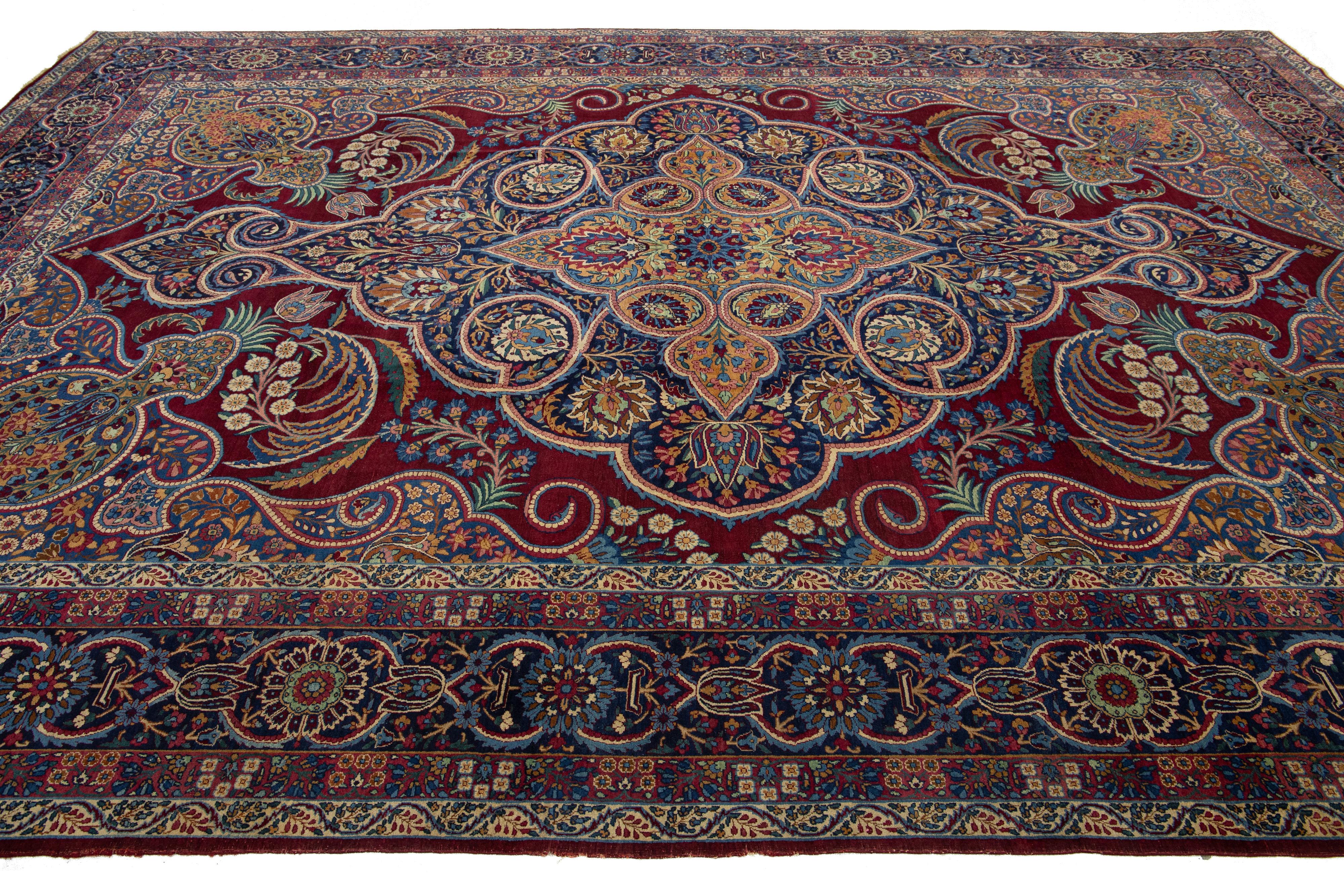 Noué à la main Ancien tapis persan Kerman en laine rouge avec un motif floral multicolore en vente