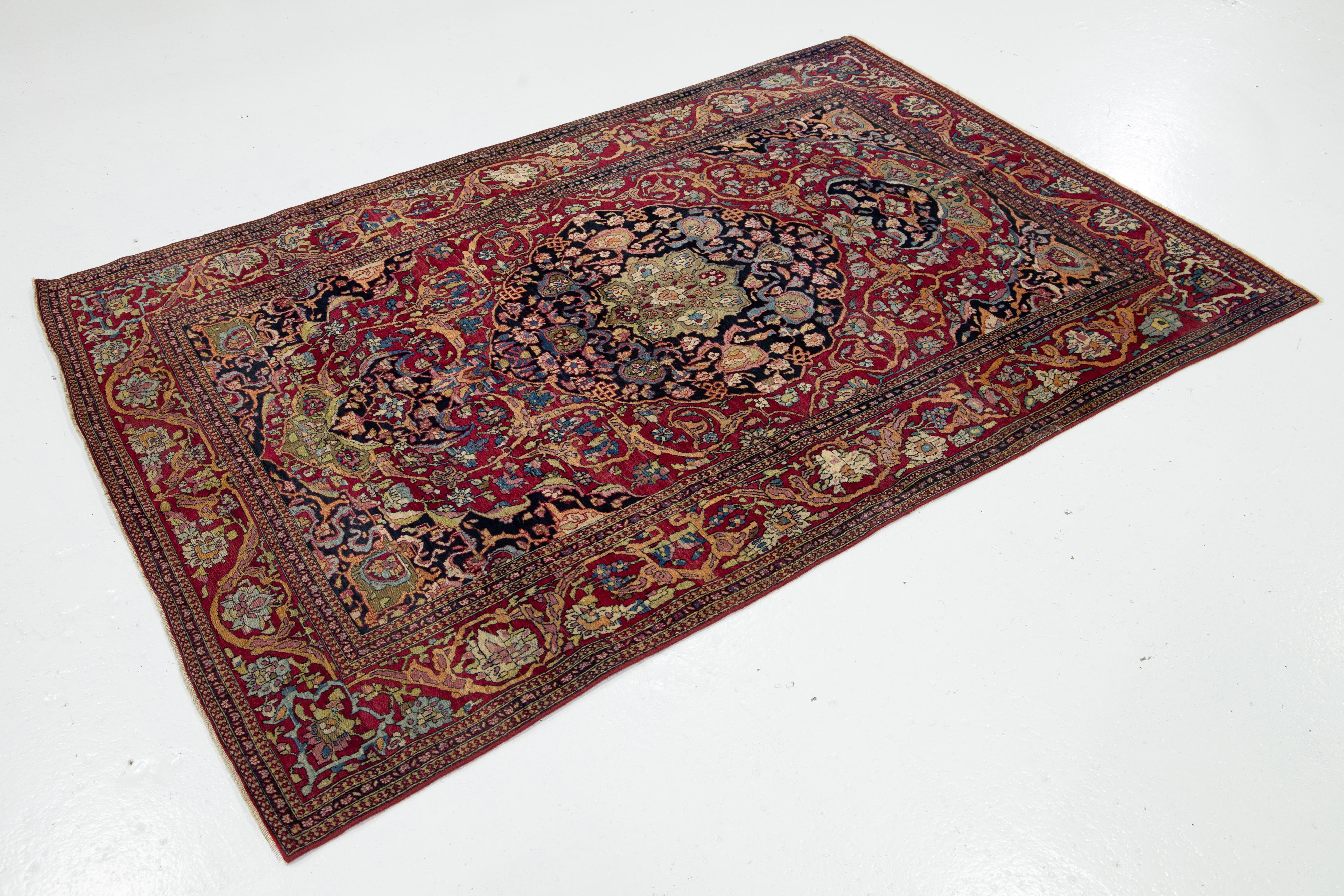 Kirman Ancien tapis persan Kerman en laine rouge avec un motif de rosette en vente