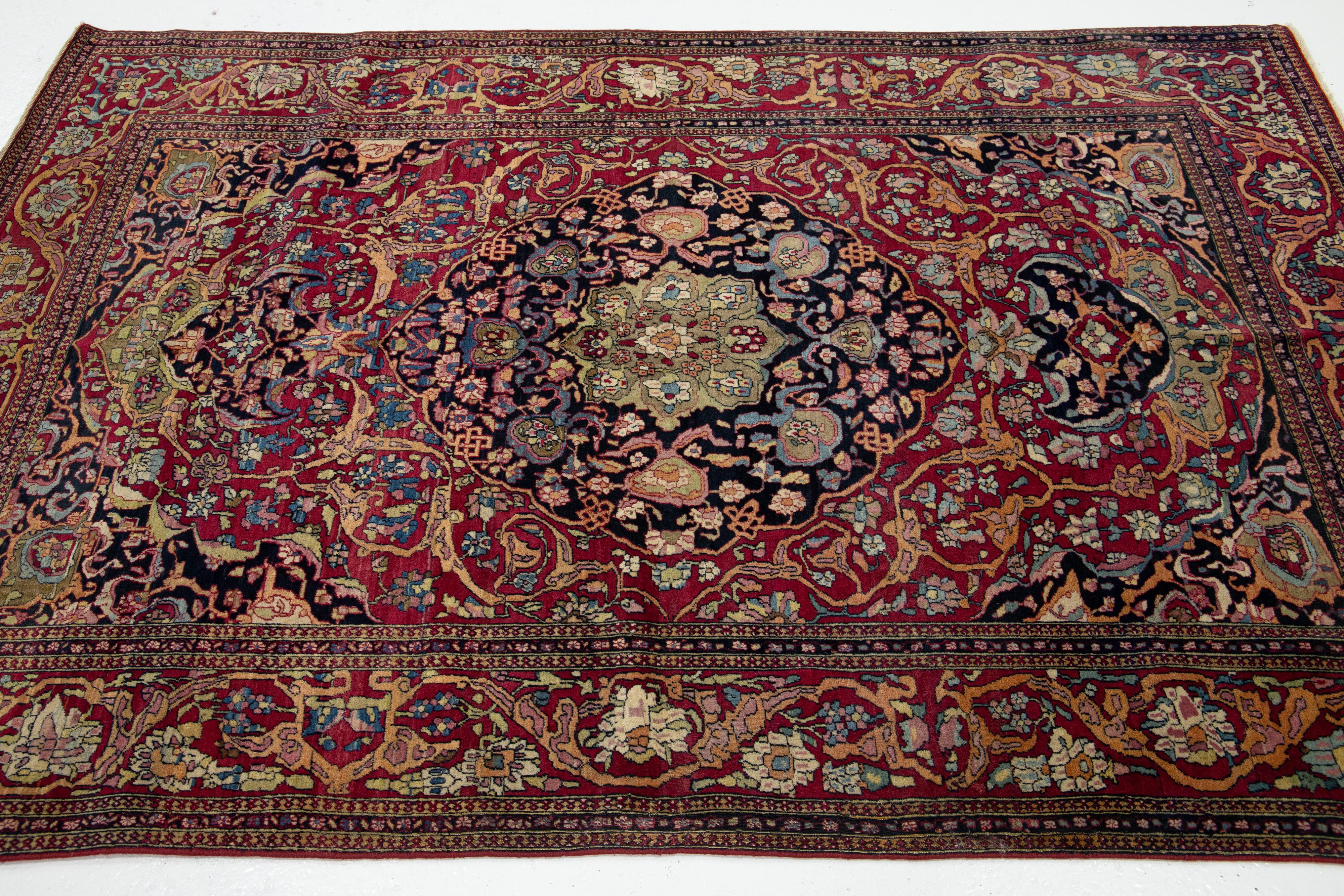 Noué à la main Ancien tapis persan Kerman en laine rouge avec un motif de rosette en vente