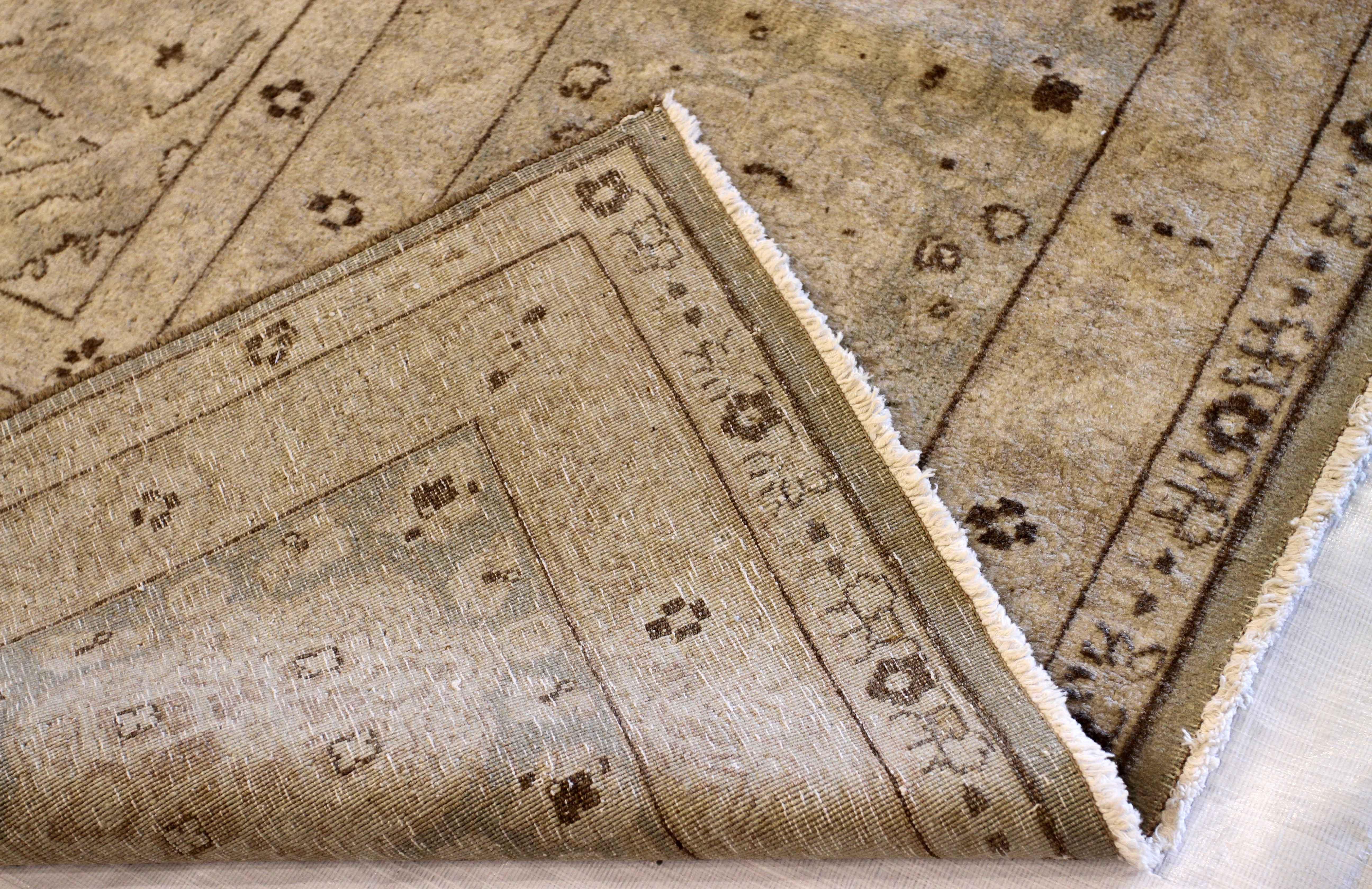 Made of exquisite wool and all-natural vegetable dyes, this handwoven antique Persian rug was created in the 1950s. It features refined floral patterns that made Kerman weavers well-known in the rug world. For color, it has a subtle mix of ivory,