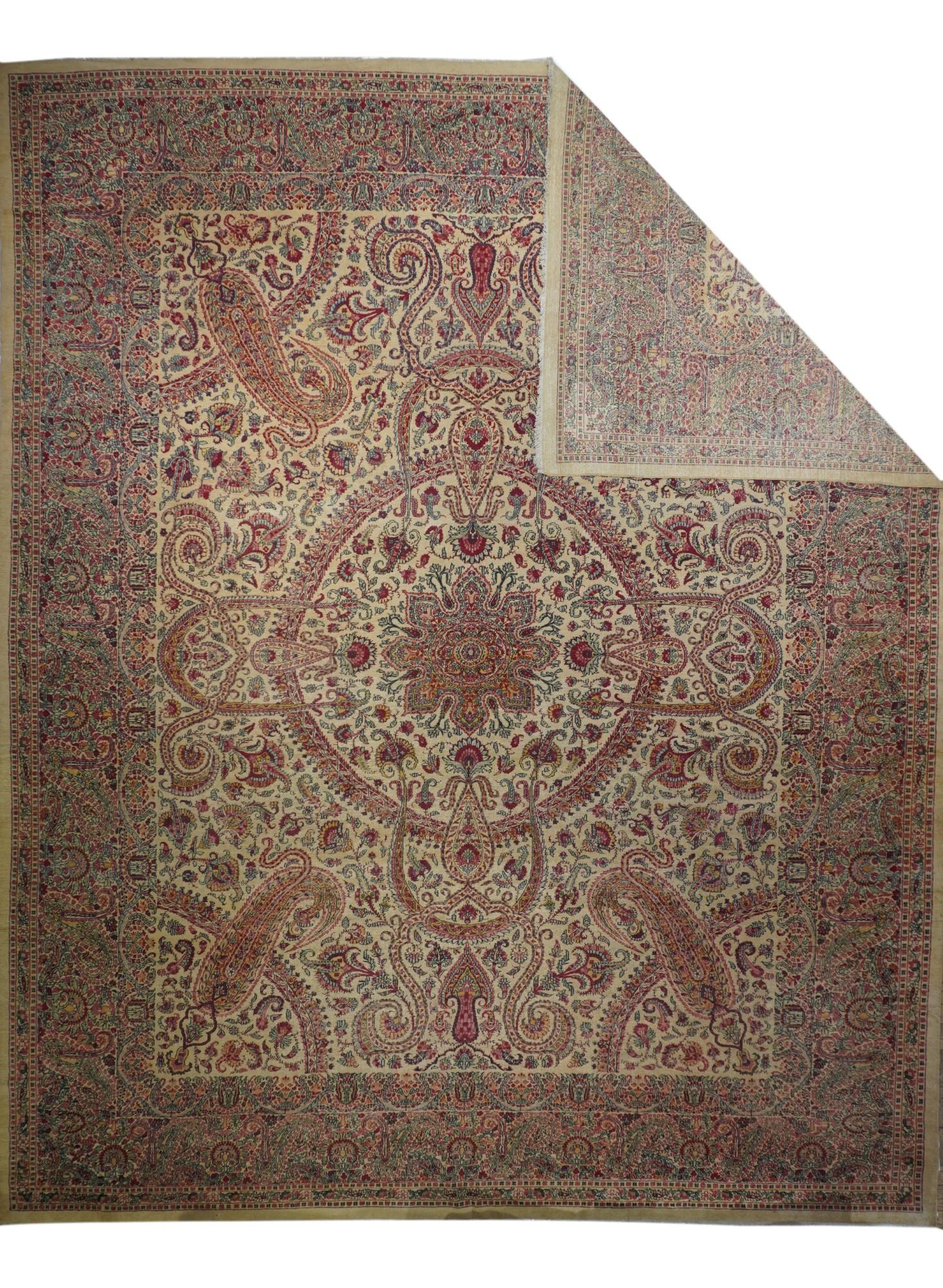 With a general warm gold tonality, this interwar west Anatolian carpet shows an open medallion with two layers of blossoming volutes and curled acanthus leaves, with en suite pendants, on an open field. Broad vase, volute and palmette main border.