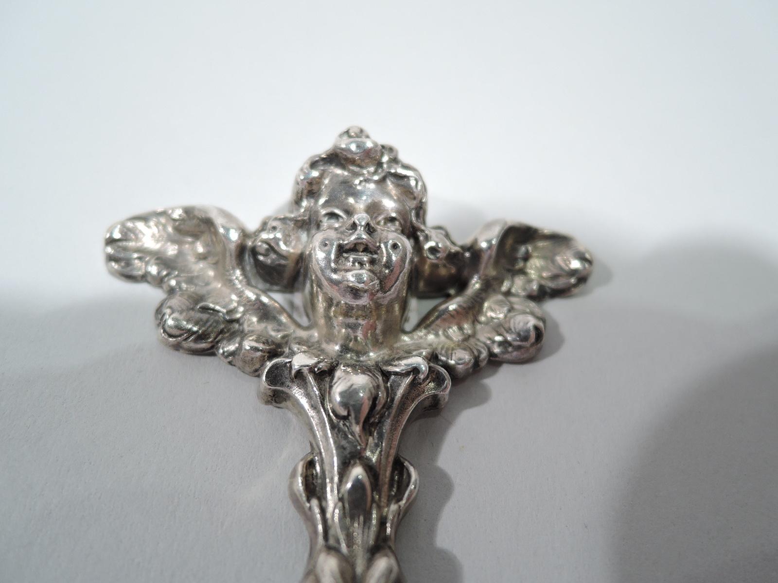 Turn of the century Art Nouveau sterling silver bookmark. Made by William B. Kerr in Newark. Dagger blade engraved with interlaced script monogram set in open frame. Cast terminal in form of winged cherub, a guiding spirit to help you keep your