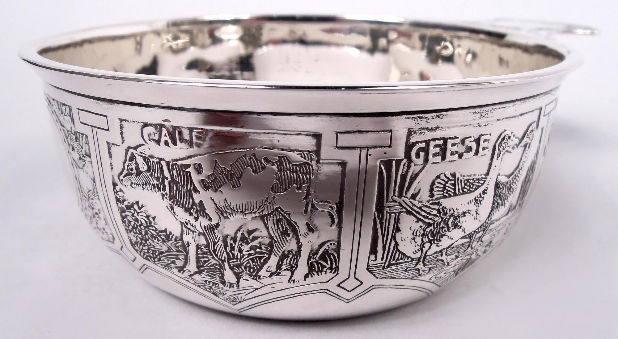 Edwardian sterling silver porringer. Made by William B. Kerr in Newark, ca 1910. Round and curved with solid shaped handle. Acid-etched menagerie of farmyard animals, including mud-spattered pigs, clucking chickens, and docile donkeys. Round frame