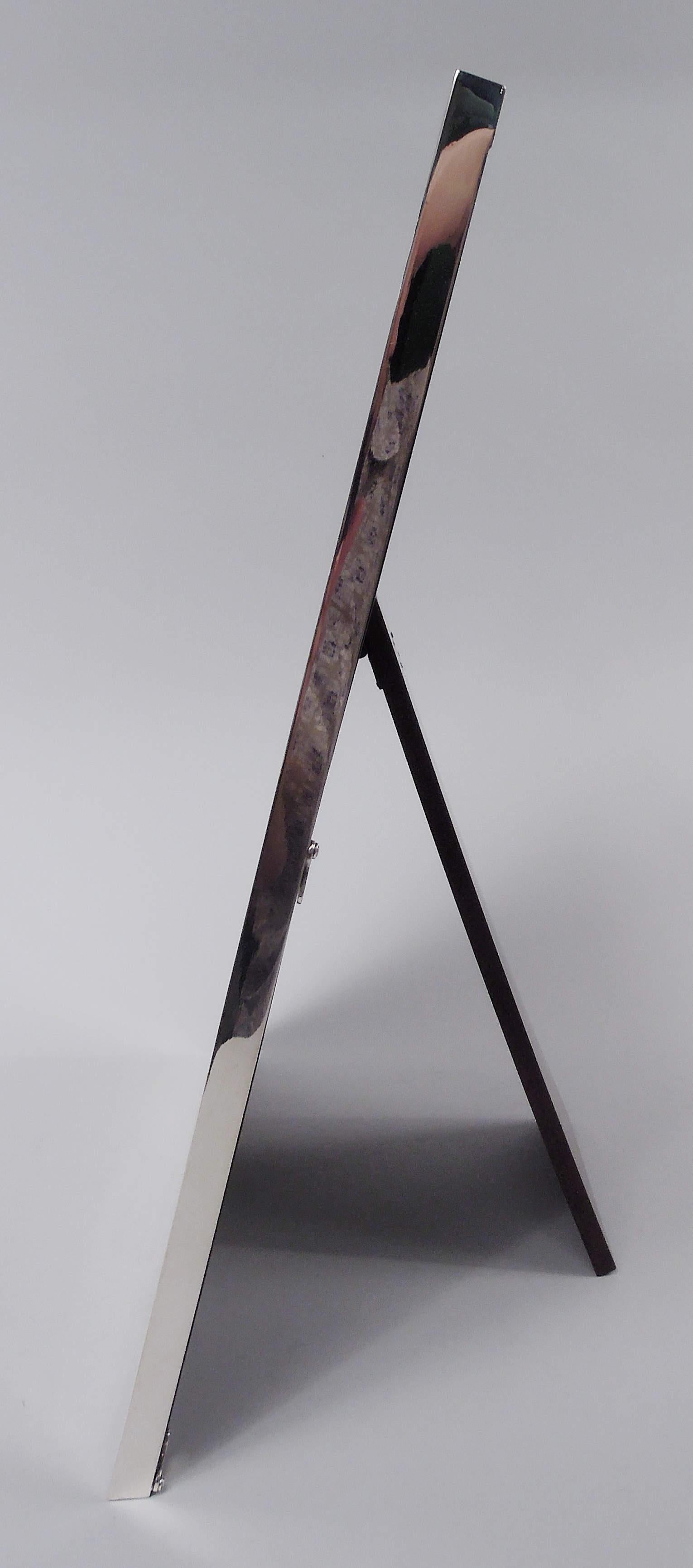 Cadre photo moderne en argent sterling. Fabriqué par William B. Kerr à Newark, vers 1920. Fenêtre rectangulaire dans un cadre plat avec des feuilles stylisées et gravées à l'acide aux angles et un bord cannelé. Au bas du rectangle (vacant). Doublure