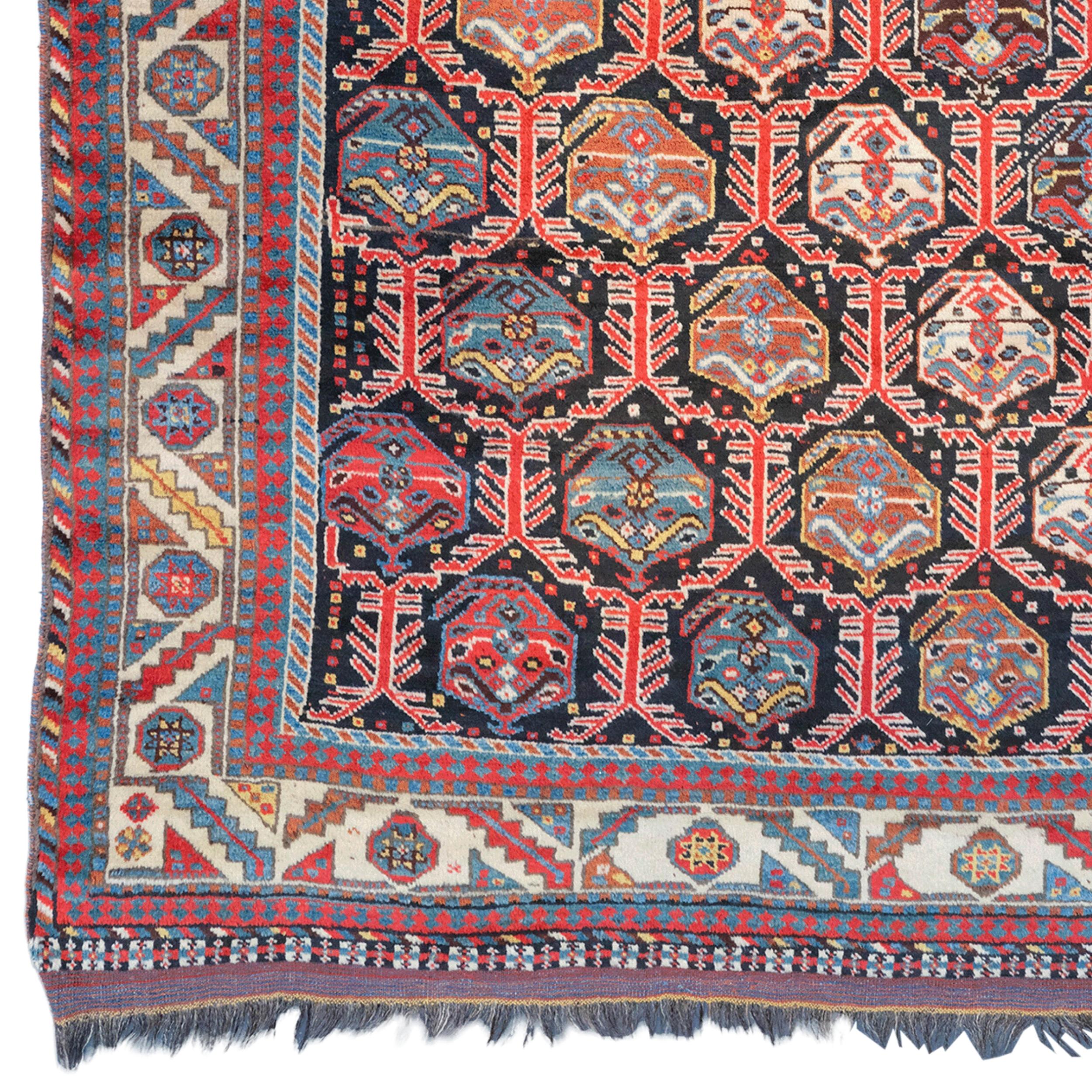 This antique Kahmseh rug is a rare artifact from the late 19th century. Kahmseh carpets are carefully woven by the nomadic Kahmseh tribe living in Southern Iran. This carpet attracts attention with its rich color palette and complex geometric