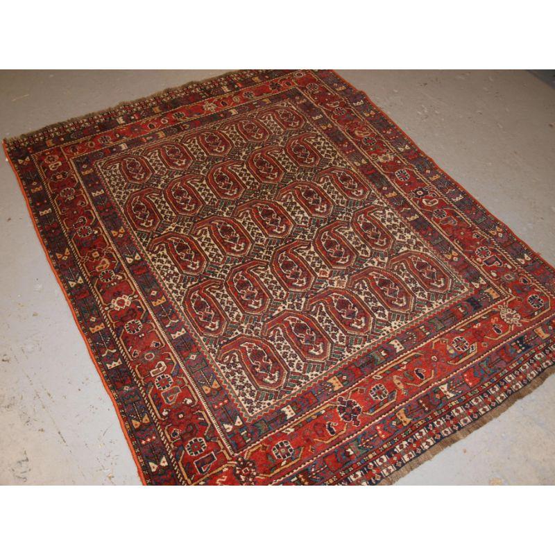 Antique Khamseh tribal rug with the well known large scale boteh design on an ivory ground.

The rug is covered with five rows of large boteh and in between them the field is covered in 100's of very small boteh. The border design is of a classic